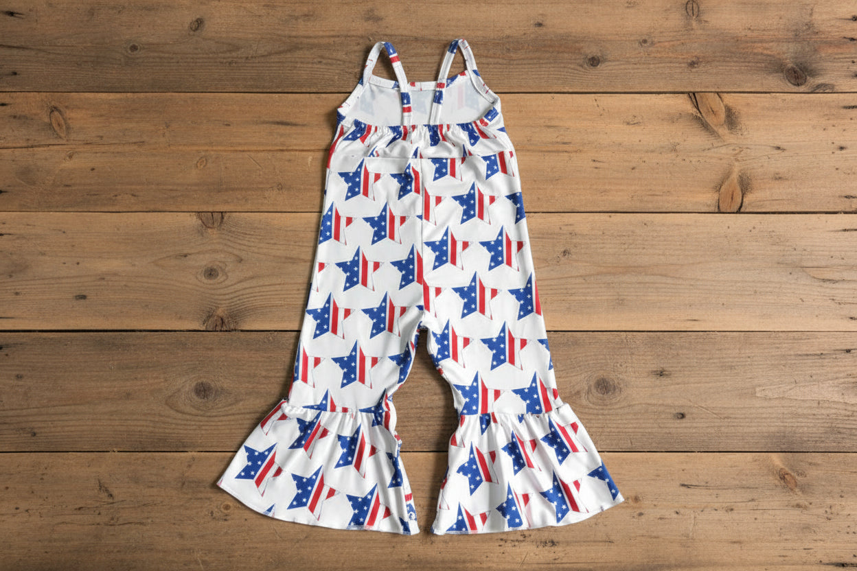 Children's romper with red, white, and blue star pattern on a barnwood background