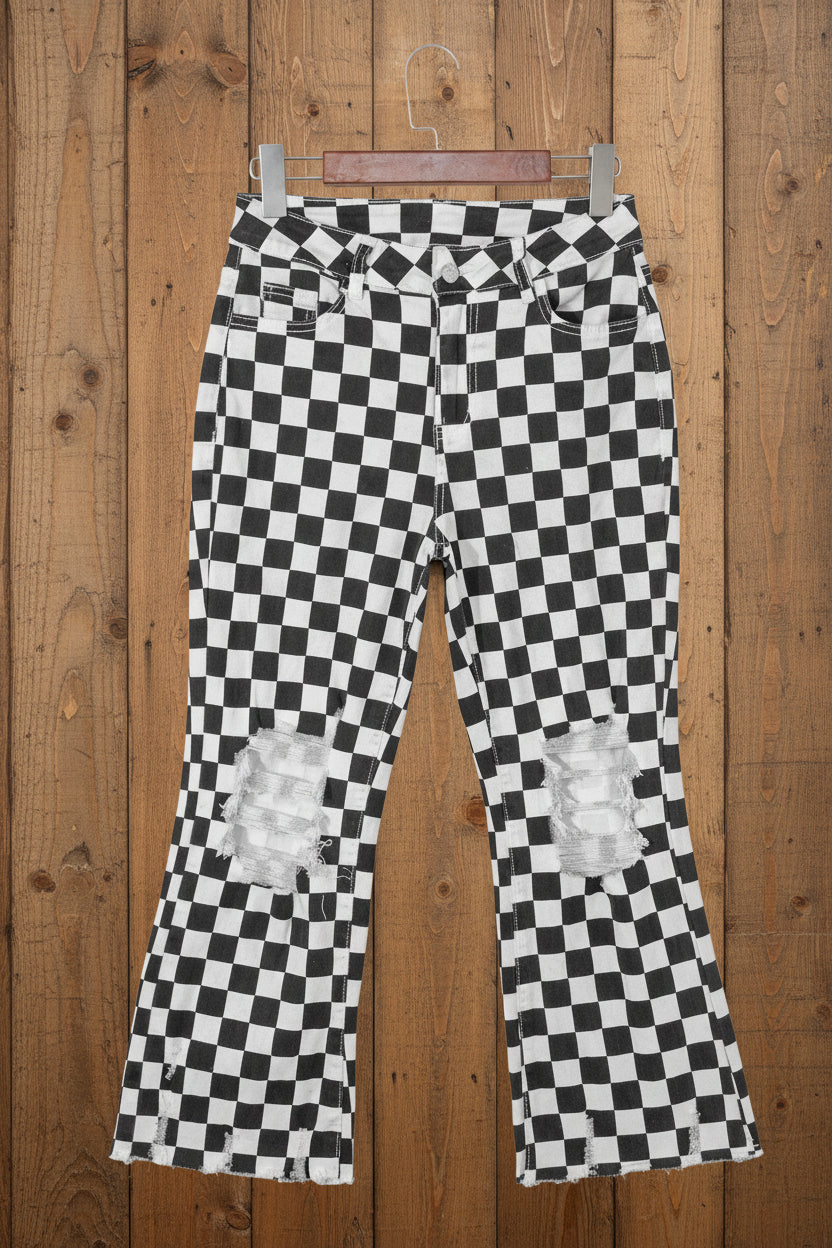 Black and white checkered pants with distressed knees on a wooden background