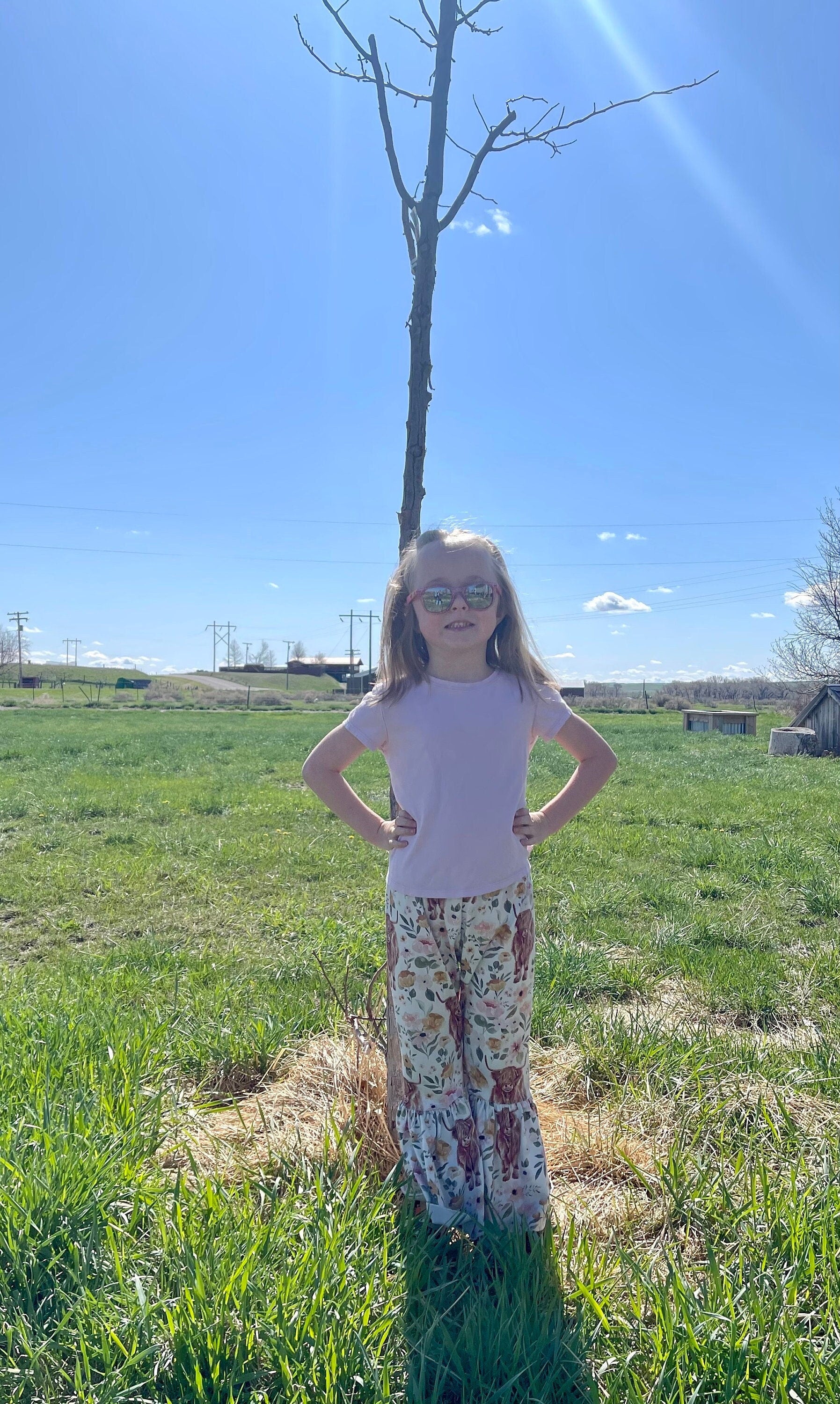 JERNIE, DAUGHTER OR rAZELS OWNER, MODELING Highland Cow Floral Bell Bottoms – Adorable Western Cow Pants for Little Cowgirls! Featuring a whimsical design of Highland cows and florals, these Western bell bottoms have a soft, stretchy fit and a fabulous flare! Comfortable and Cute!