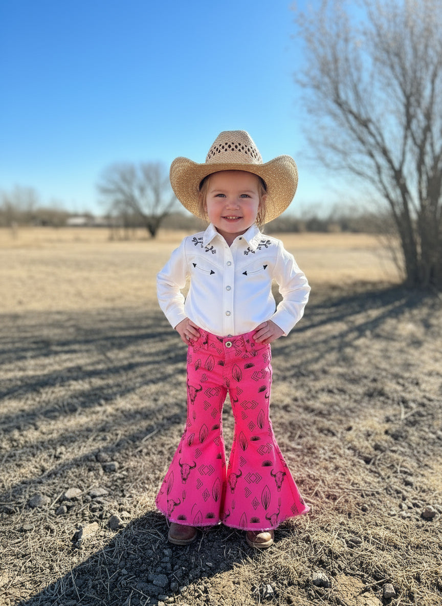 girls hot pink western jeans. Jeans feature black steerheads, arrows, cactus and western motiff with a frayed bell bottom hem.