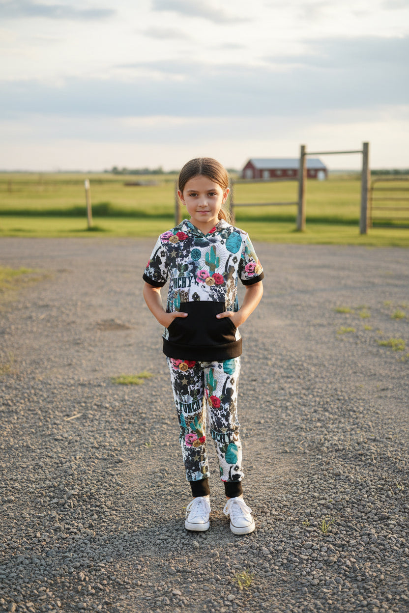 Girls Cowgirl Outfit | Western Hoodie Jogger Set for Kids This Girls PUNCHY Cowgirl Outfit is full of retro cowboy vibes. This Western outfit features an allover Western print with matching jogger pants and a lightweight, short-sleeved hoodie top.