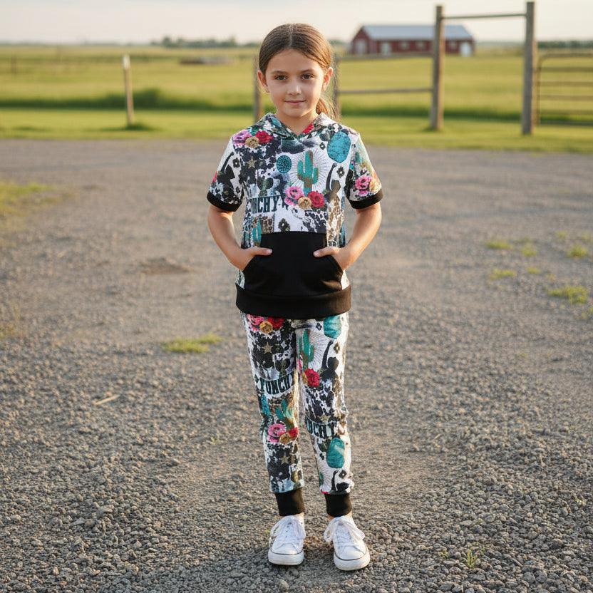Girls Cowgirl Outfit | Western Hoodie Jogger Set for Kids This Girls PUNCHY Cowgirl Outfit is full of retro cowboy vibes. This Western outfit features an allover Western print with matching jogger pants and a lightweight, short-sleeved hoodie top.