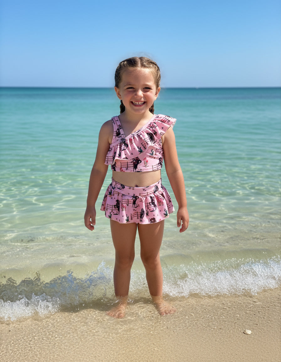 Saddle up for summer with this Pink Cowgirl Swimsuit! This Western Ruffled Swimsuit features vintage cowgirls, adorable ruffles, and a bold Wild West vibe, perfect for little adventurers. Designed for comfort and durability, it includes adjustable straps, a fully lined front, and high-quality swimsuit material. Available in sizes 0-3 months to 6/7, this Cowgirl Bathing Suit is ideal for babies and toddlers. FREE U.S. shipping on $35+ orders. Shop Razels for the best Western Bikini today!