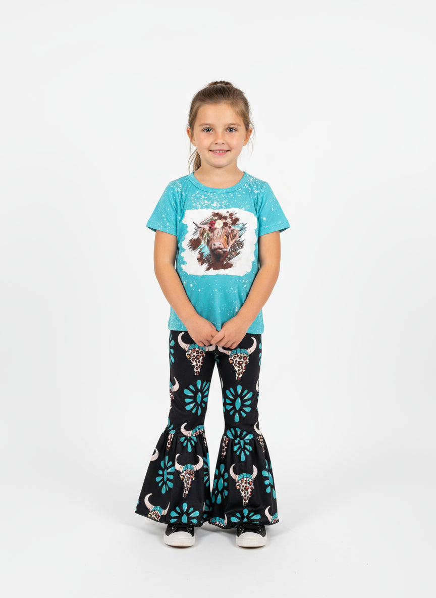 Children's outfit with blue top and black pants featuring bull designs, placed on a textured surface with a large letter 'R'.