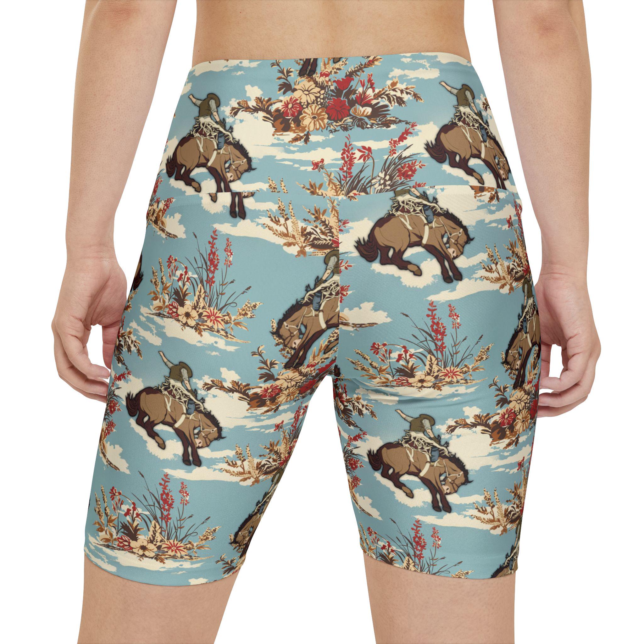 Rear view of a person wearing biker shorts with a repeating print of bison on a light blue background with clouds and floral elements.