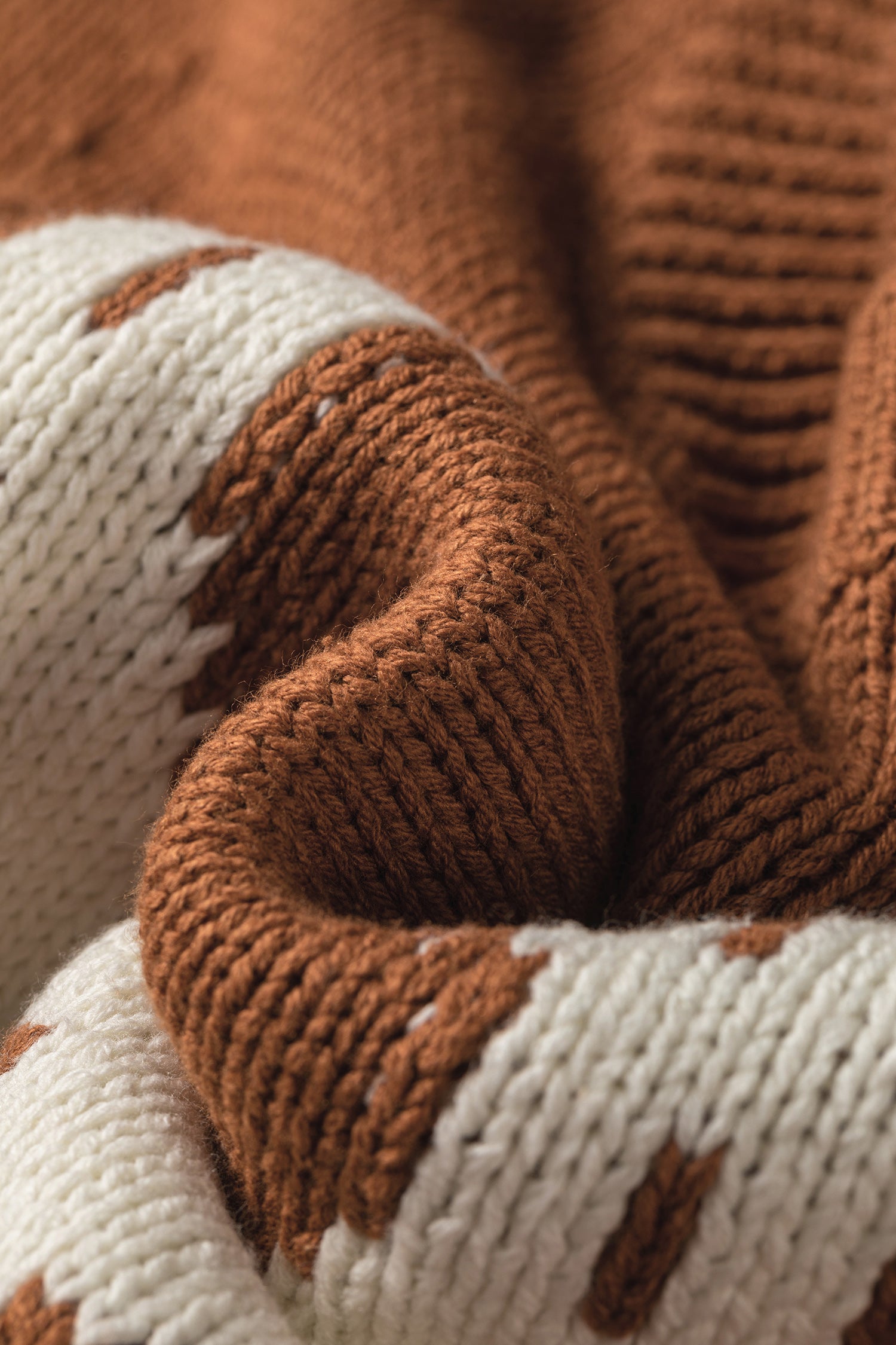 Close-up of brown horseshoe sweater, showing the detailed texture of the yarn.