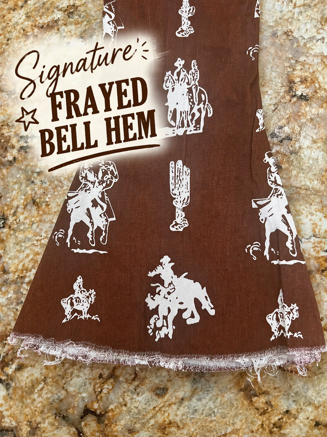 Brown fabric with white frayed bell hem and cowboy patterns on a stone surface
