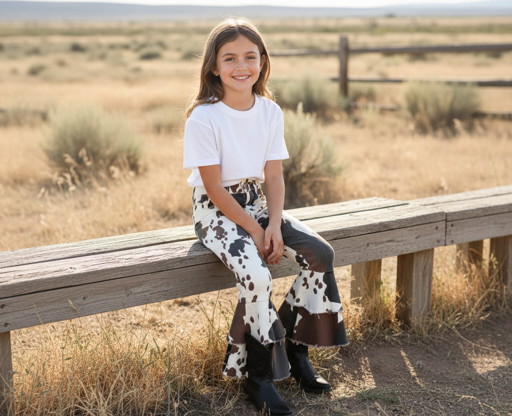 girl on bench wearing razels cow jeans