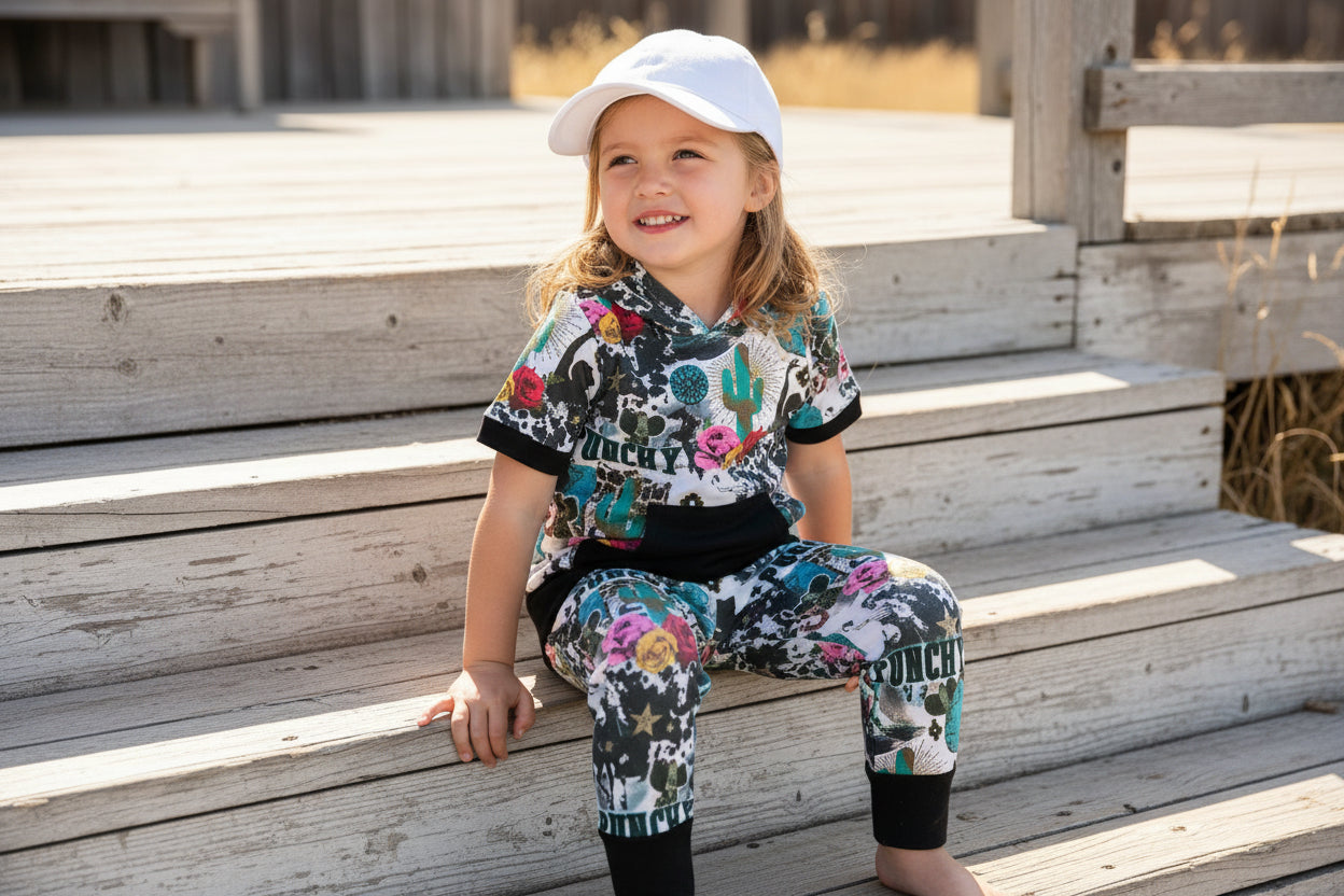 Girls Cowgirl Outfit | Western Hoodie Jogger Set for Kids This Girls PUNCHY Cowgirl Outfit is full of retro cowboy vibes. This Western outfit features an allover Western print with matching jogger pants and a lightweight, short-sleeved hoodie top.