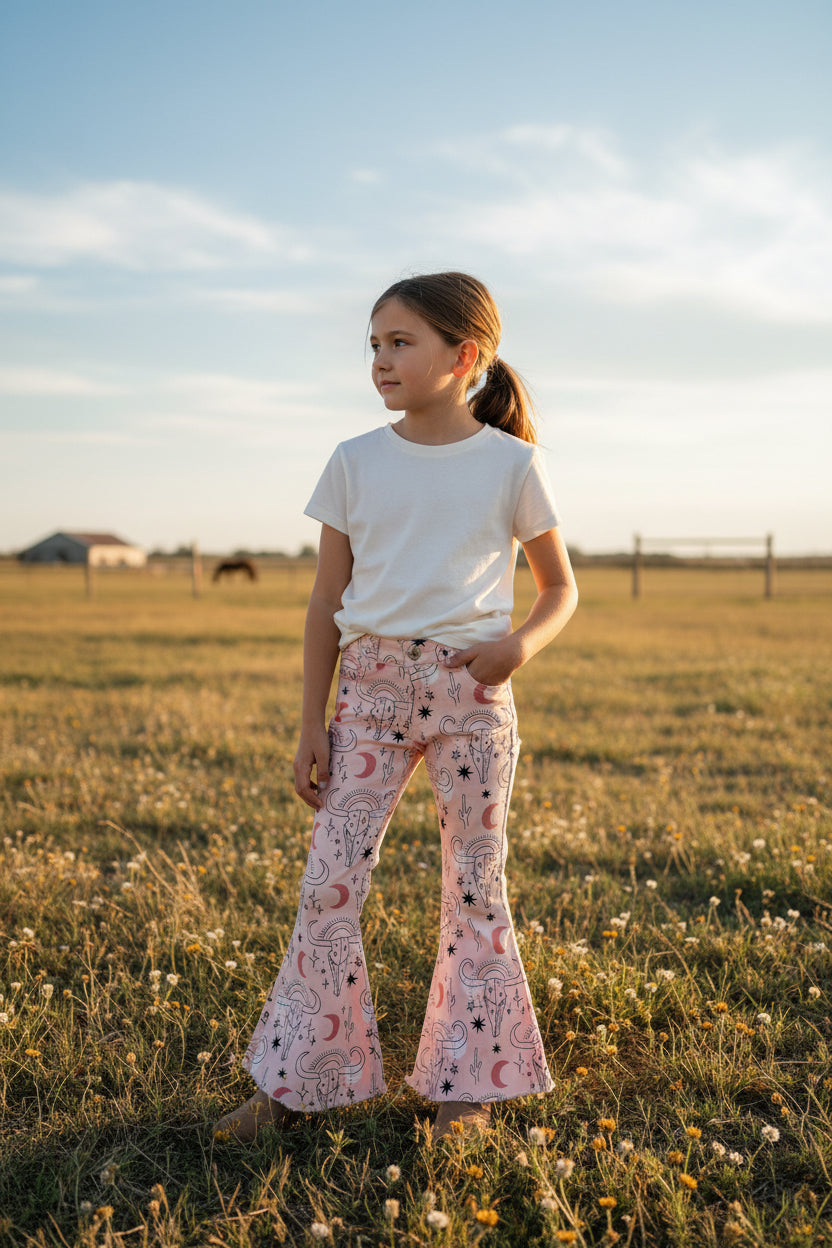 Cowgirl Pink Bell Bottoms – Western Cow Skull Jeans (ONLY 2T, 3T, 4T LEFT!) New cowgirl jeans just dropped—and aren’t they fabulous?! 💓 With cow skulls, moons, cactus, stars... oh my! These pink bell bottoms are full of western sass and sweet desert vibes. ✓ Functional front and back pockets ✓ Adjustable waistband for a perfect fit ✓ Stretchy cotton/spandex blend for all-day comfort ✓ Button and zipper closure ✓ Frayed hems for that trendy flair