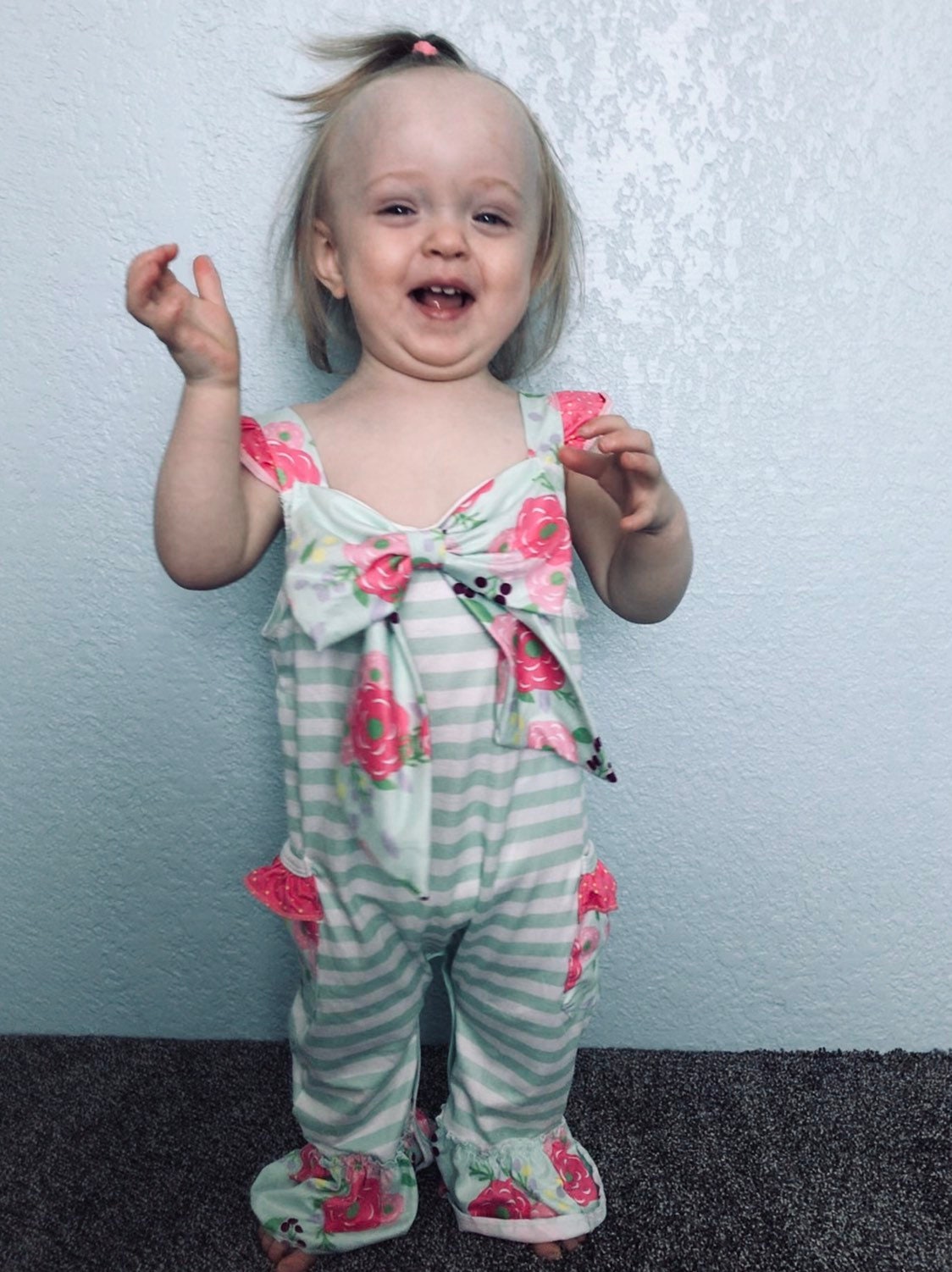 A baby wearing a green and white striped jumpsuit with pink floral accents and a large bow. The jumpsuit has ruffles at the bottom of the legs and pockets on the sides. 🌸 The Sweetest Springtime Romper – Now Just $10! 🌸
Size: 18/24 Months – LAST ONE!
Pink Floral + Mint Stripe Jumpsuit Romper
This romper has to be the cutest thing I’ve ever seen!
✓ Ruffled tank straps
✓ Full leg snaps for easy changes
✓ Side pockets (yes, even tiny ones!)
✓ Soft, stretchy, and pull-on easy