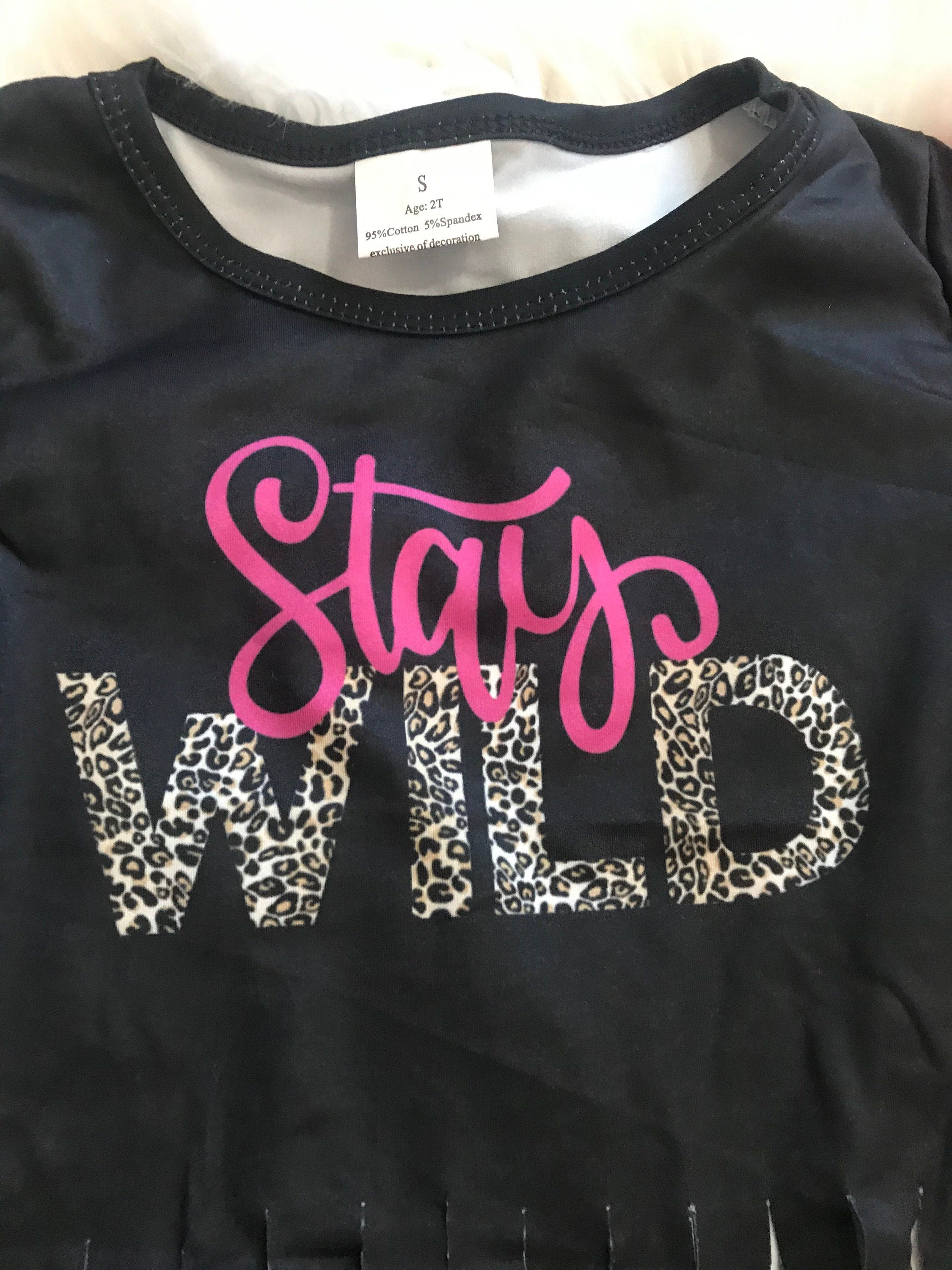 Stay Wild Girls Bell Bottom Set. Features a black Fringed Shirt with a bold "Stay Wild" design in pink and cheetah print, perfectly paired with vibrant serape-striped bell bottoms. Ships FREE with $35+ purchase.