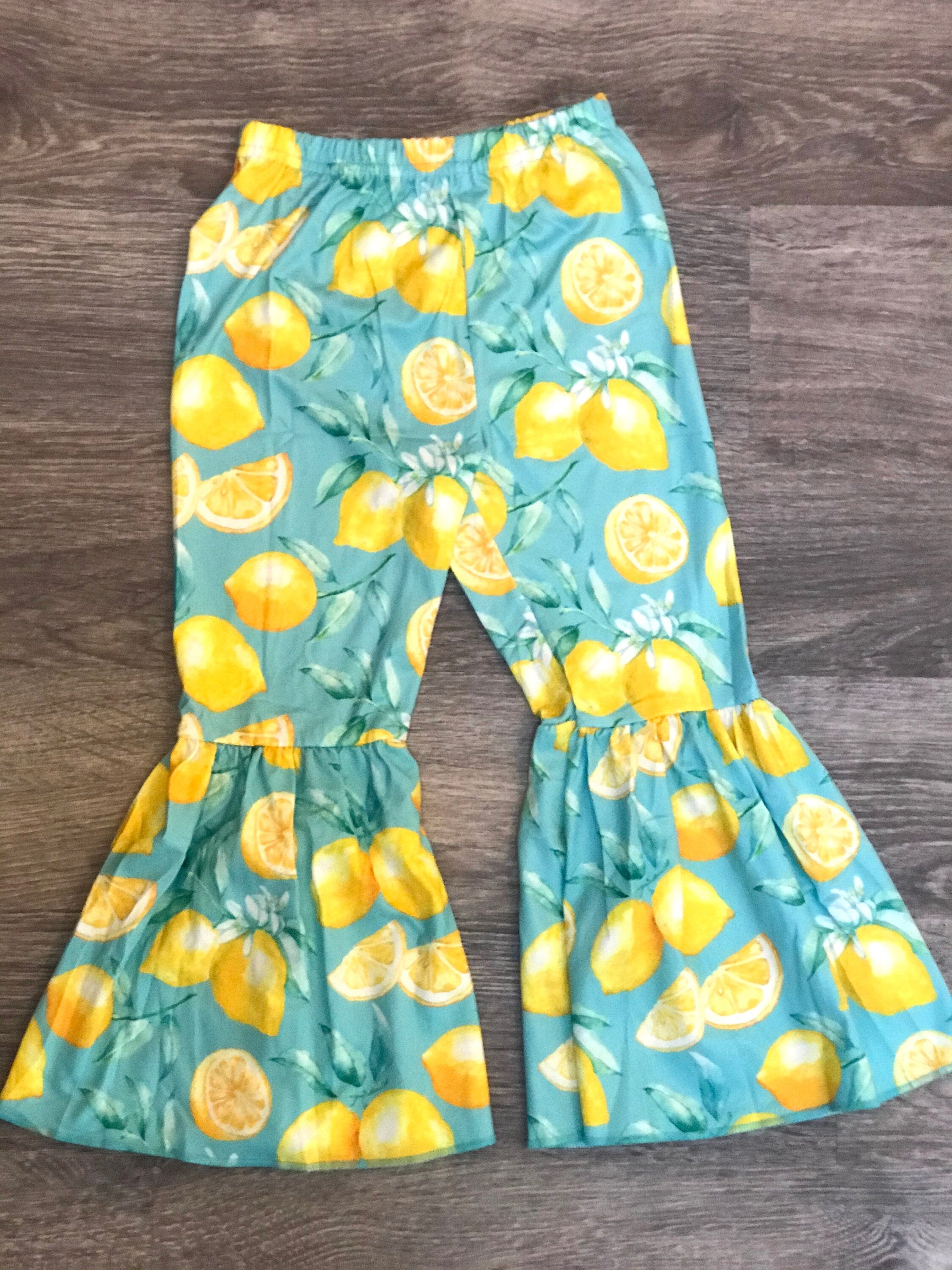 🍋 Mama's Main Squeeze Bell Bottom Outfit - a cheerful lemon-themed outfit! This adorable set features a playful "Mama's Main Squeeze" t-shirt and bell bottoms with an all over lemon print, adding a burst of sunshine to any day.