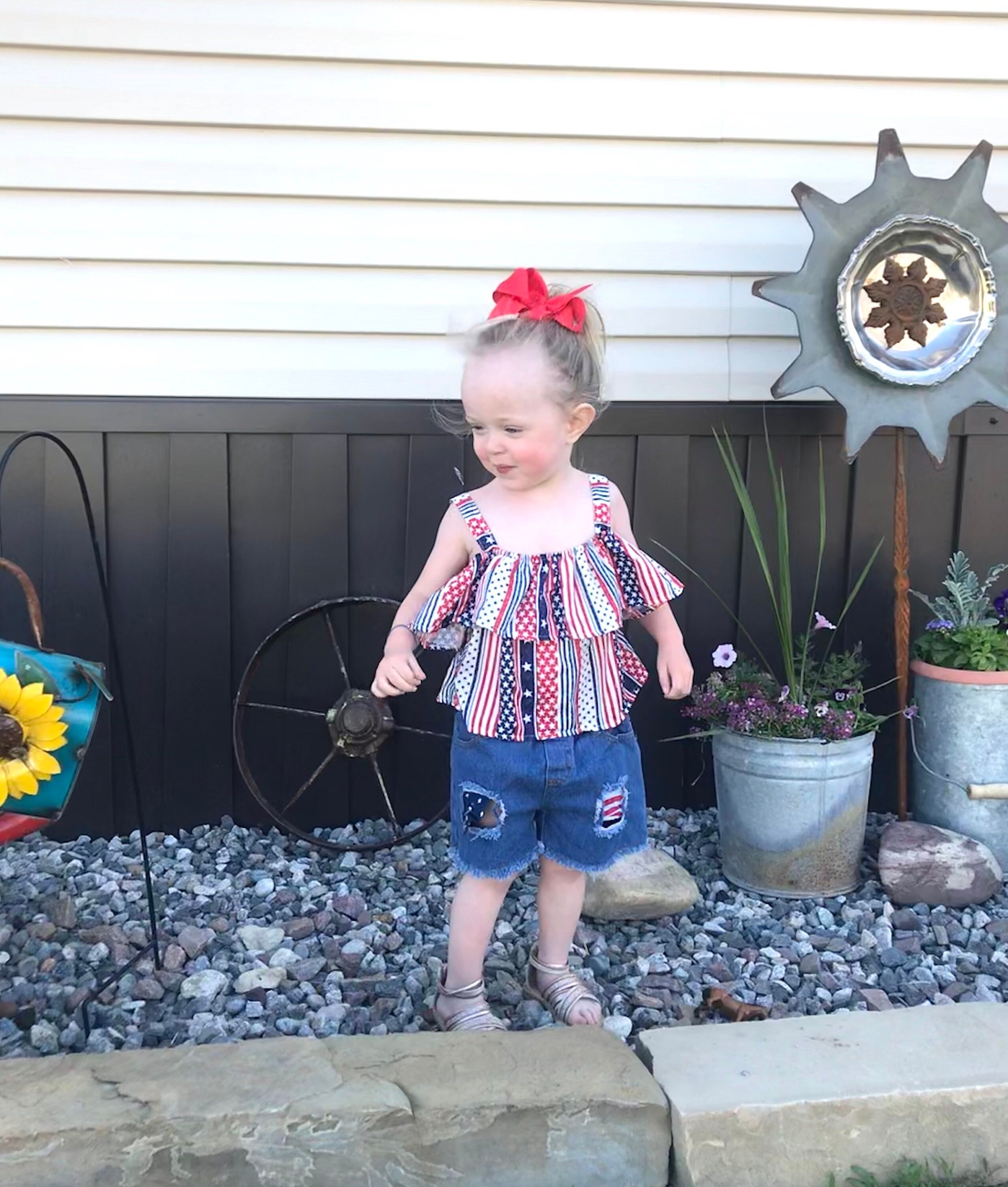 4th of July Toddler Outfit | Flag Shirt & Distressed Jean Shorts Set | USA Kids Clothes | Sizes 2T–5T ⭐ 50% OFF! ⭐ Oh my stars… and stripes!
This 4th of July short outfit is the ultimate summer must-have for your little firecracker! Classic light-wash denim with festive red, white, and blue peeking through the distressed details.
A bold American flag print meets sweet style with cold-shoulder cutouts and a flouncy ruffle.