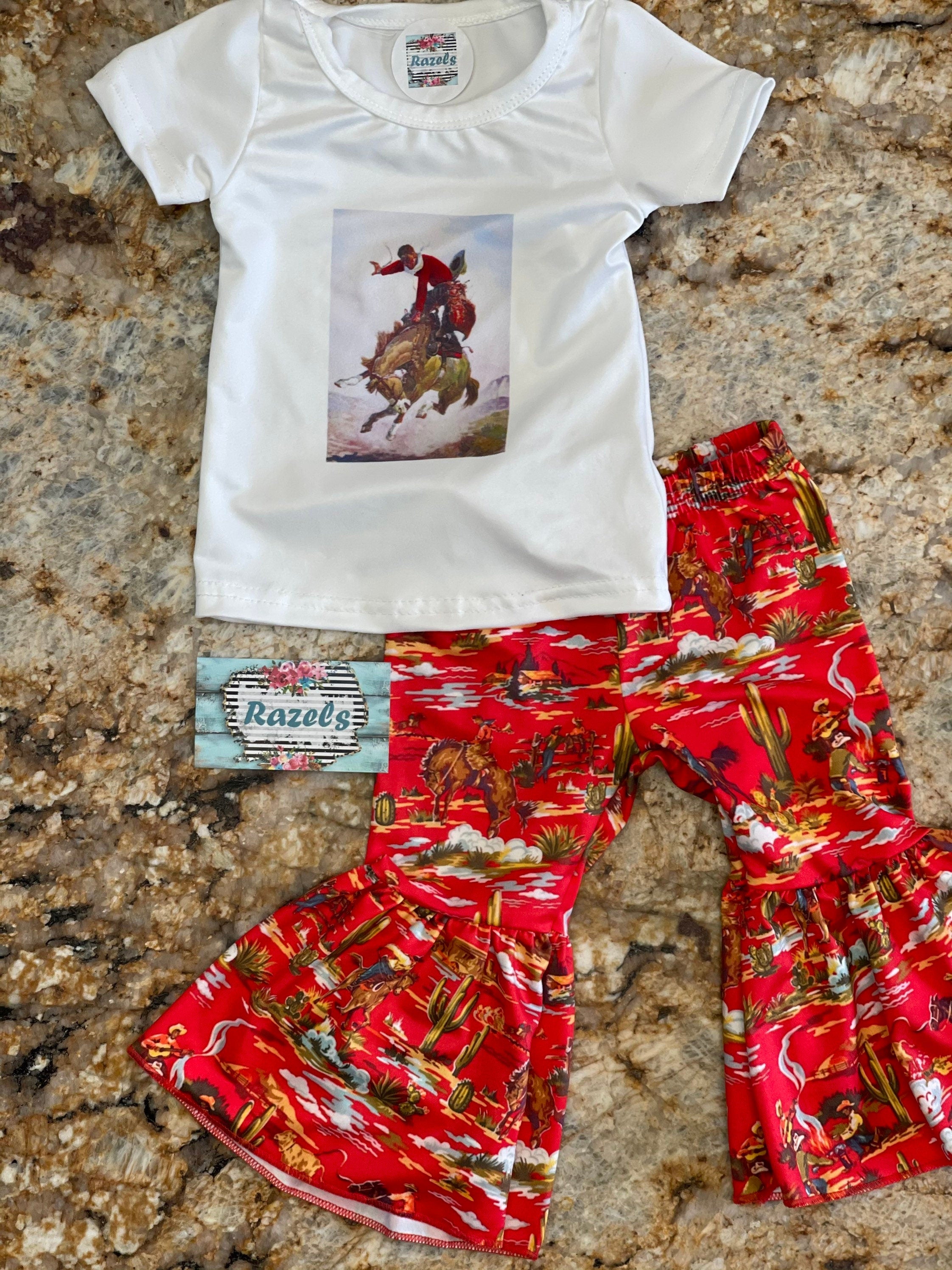 girls bell bottom outft. Top is white with a bucking horse and cowboy centered on t-shirt.The bell bottom pants are red with bucking horses, cowboys, cactus western scene