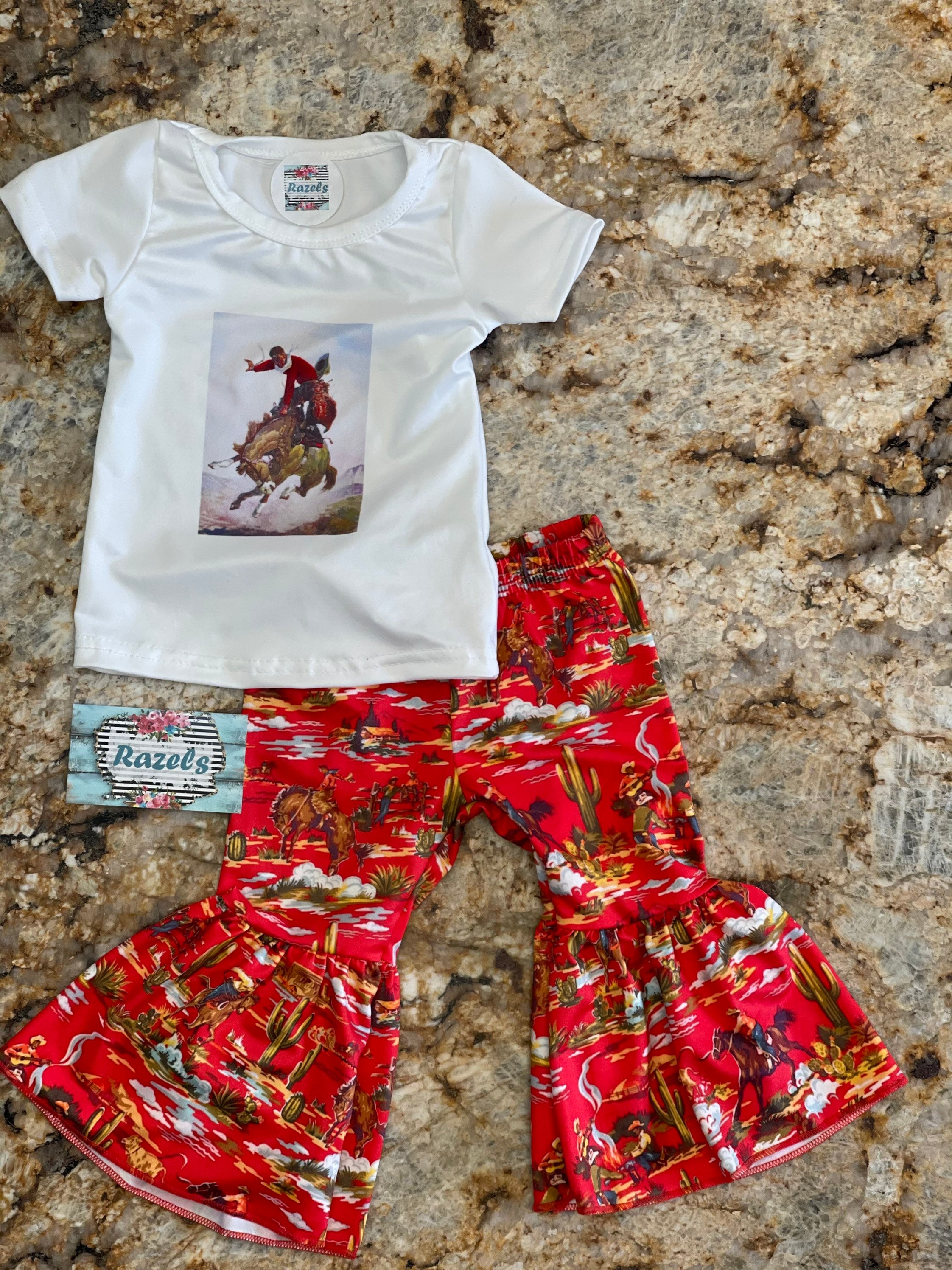 girls bell bottom outft. Top is white with a bucking horse and cowboy centered on t-shirt.The bell bottom pants are red with bucking horses, cowboys, cactus western scene