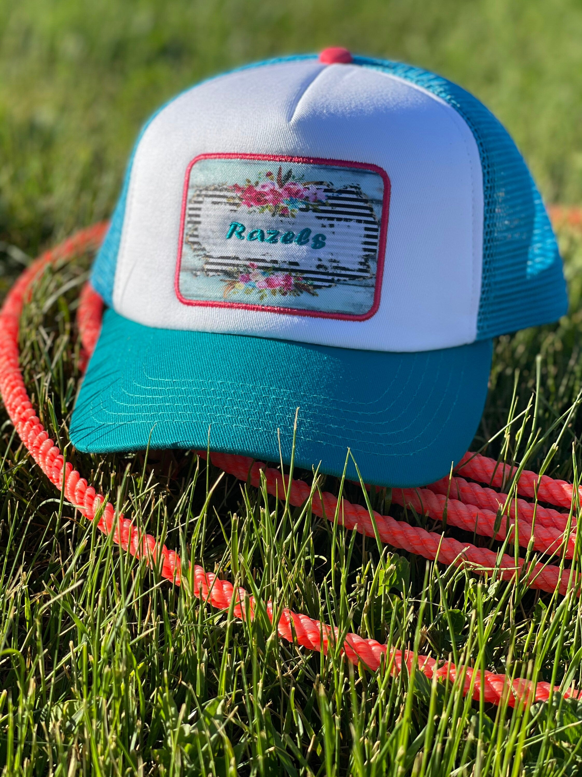 These high-quality 5-panel trucker caps are perfect for adding a playful touch to any outfit. Featuring a snapback closure for a comfortable fit and a charming Razels patch, these caps blend style with functionality.