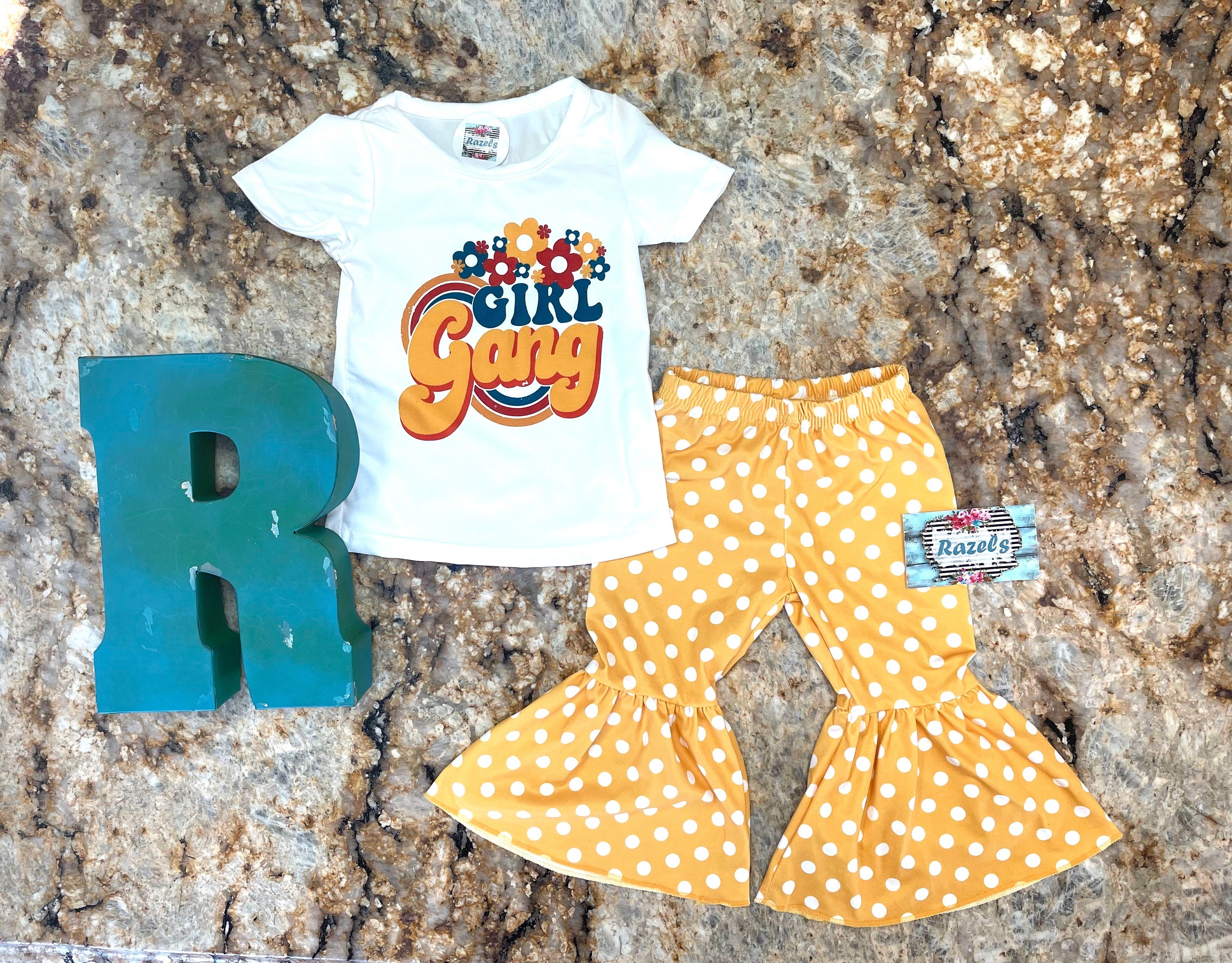Girl Gang Shirt and Yellow Polka Dot Bell Bottom Outfit – Retro Floral Vibes for Girls! 🌼💪🏽
This fun, bright Polka Dot Bell Bottom outfit is perfect for your little fashionista! I love the retro floral vibe, and what could be more fun than yellow polka dot bell bottoms? This adorable outfit is ready for sunshine and warm weather! 🌞 Or, pair it with a denim jacket for those cooler days, especially if you live in Montana like us! 😉🤠Ships FREE with $35+ purchase from MONTANA.