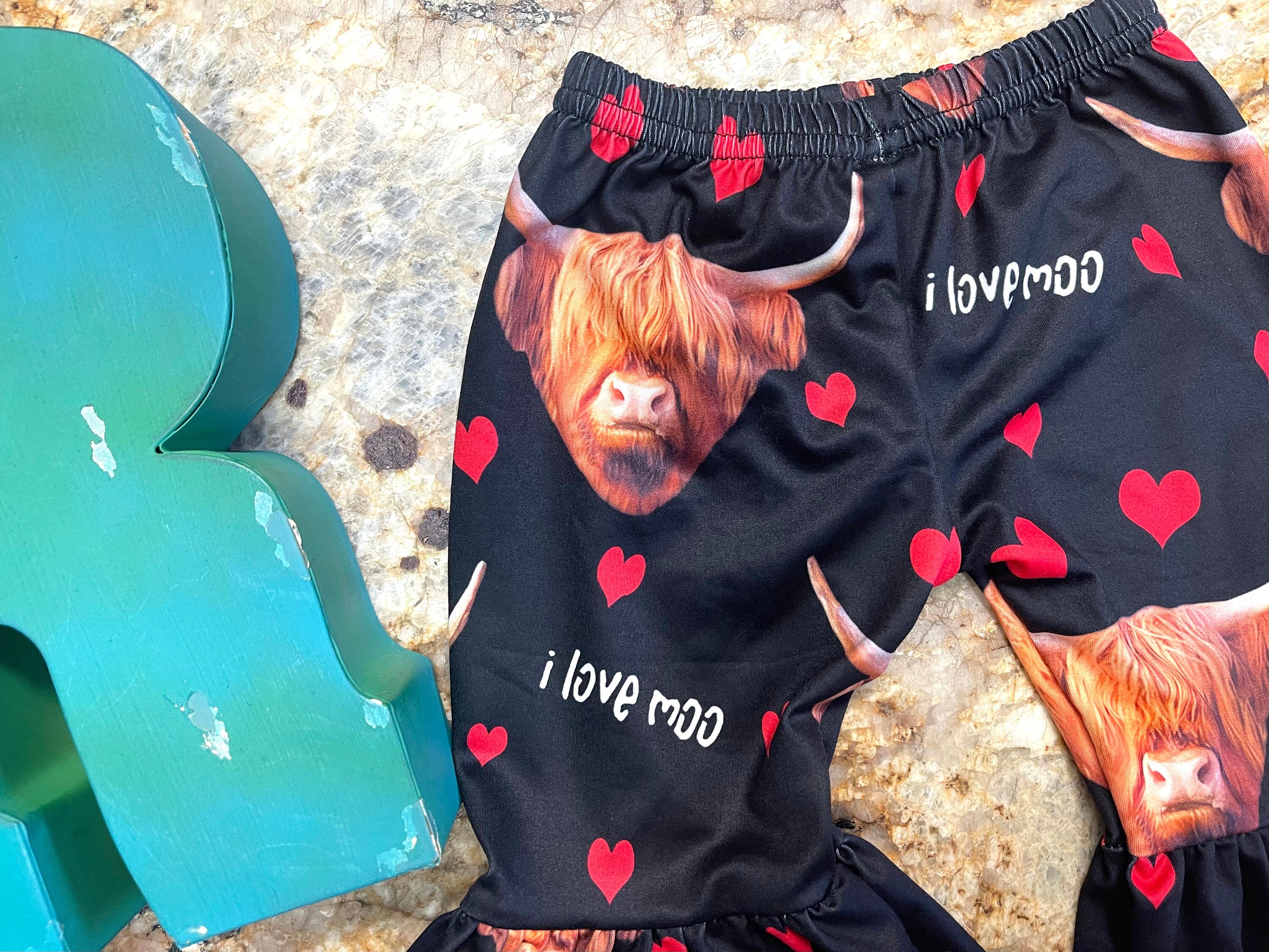 Girls Black bell bottom pants that feature Scottish highlander cows, red hearts and the words I Love MOO