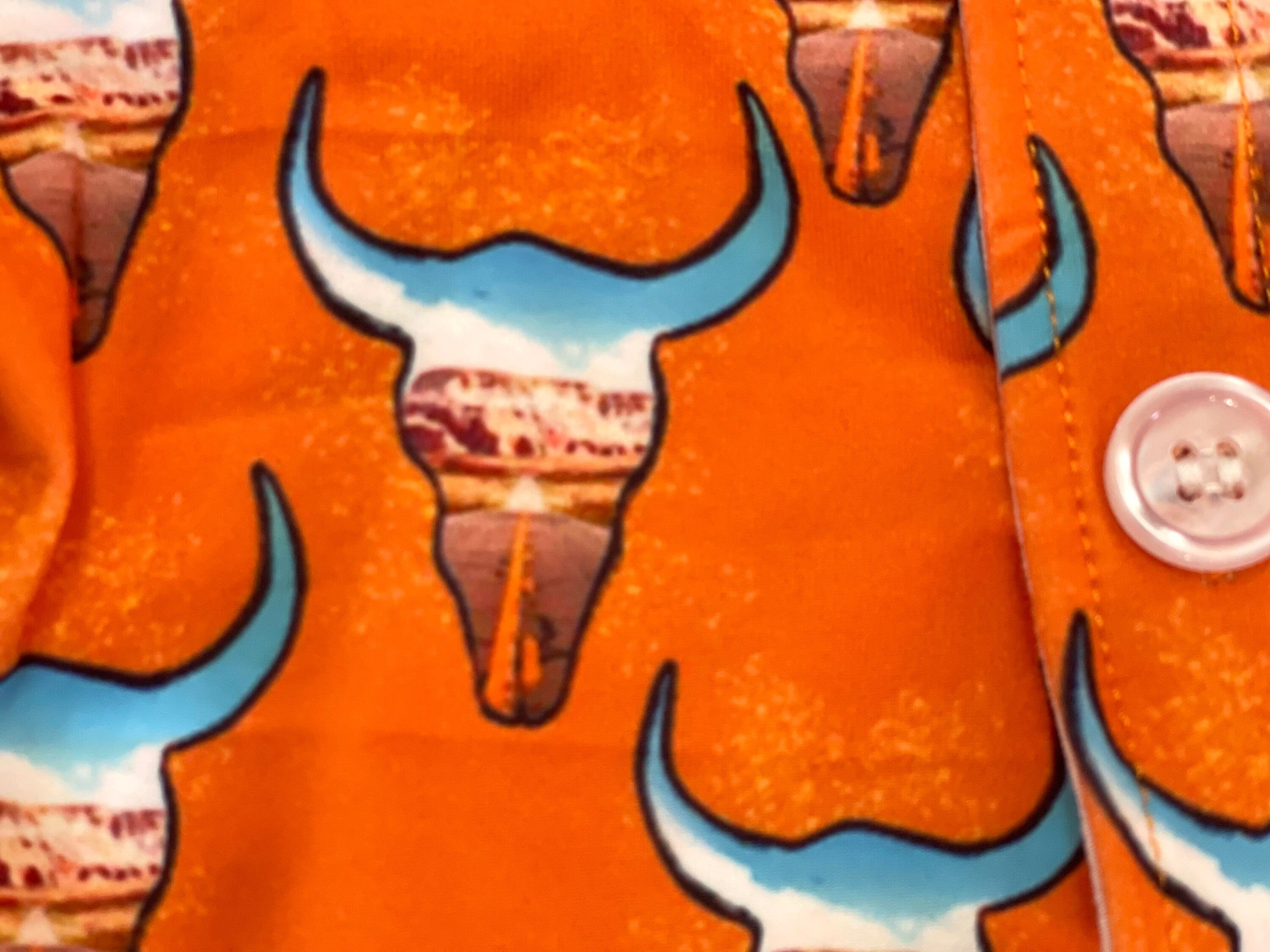 Give your little cowboy or cowgirl a shirt that’s as bold as the Wild West! 🤠🧡 This kids’ Western button-up shirt features steer heads filled with a desert highway sunset scene, all set on a bright orange background. It’s a standout piece for rodeos, family photos, or just everyday cowboy style.
✓ Classic button-up design with short sleeves
✓ Bright orange with steer head + desert scene print
✓ Perfect for Western outfits, rodeo kids, or cowgirl chic