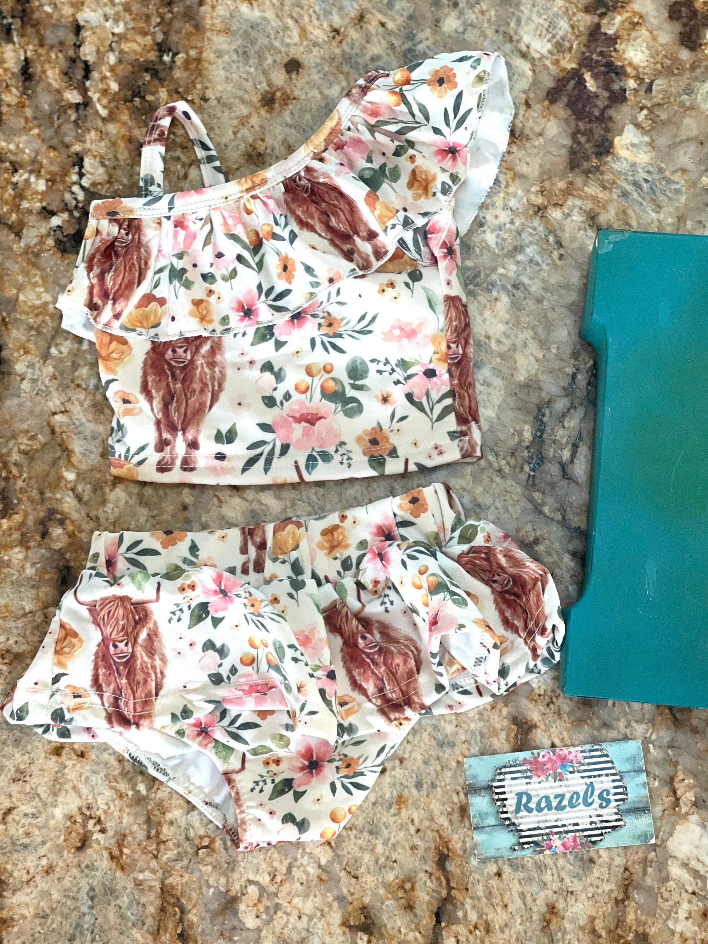 Highland Cow Swimsuit – The Sweetest Western Tankini! 🐂💖
Calling all Highland Cow lovers! This adorable Highland Cow Swimsuit features the funnest (yes, that's a word for this cuteness!) Scottish Highlander Cows and Flowers in a stylish tankini design. With a ruffled neckline and a skirted bottom, this Cowgirl Swimsuit for Kids is as sweet as it is fun! 🌸🐂
✔ Available Sizes: 0-3 months to 8/9!