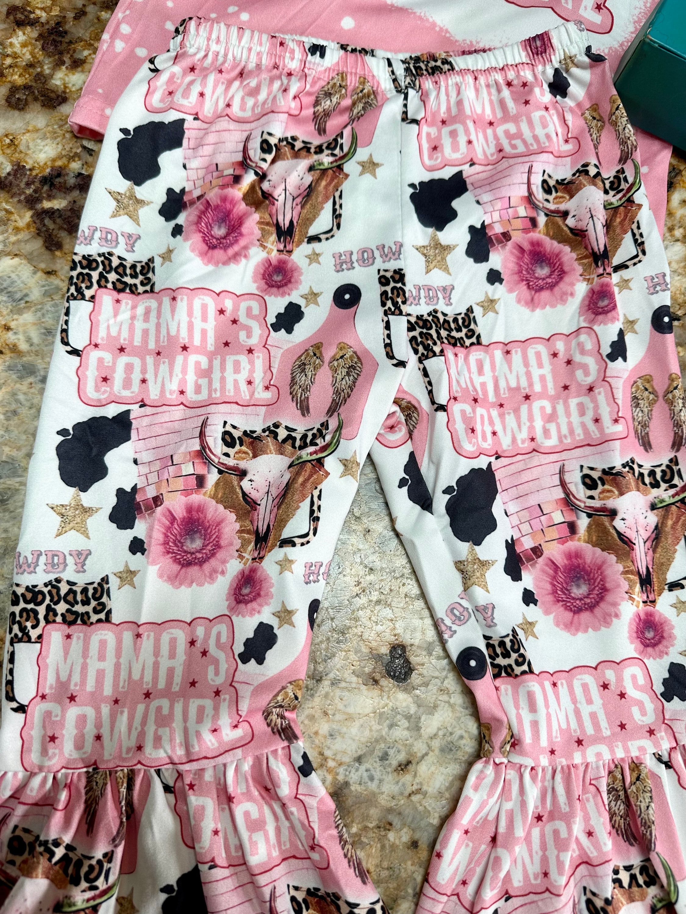 Mama’s Cowgirl Bell Bottom Outfit features a pink bleach-splattered tee with Mama's Cowgirl on the front and the bell bottom pants feature the funnest cowgirl motif with cheetah rodeo back numbers, disco balls, cow skulls, cowprint, and gold stars!