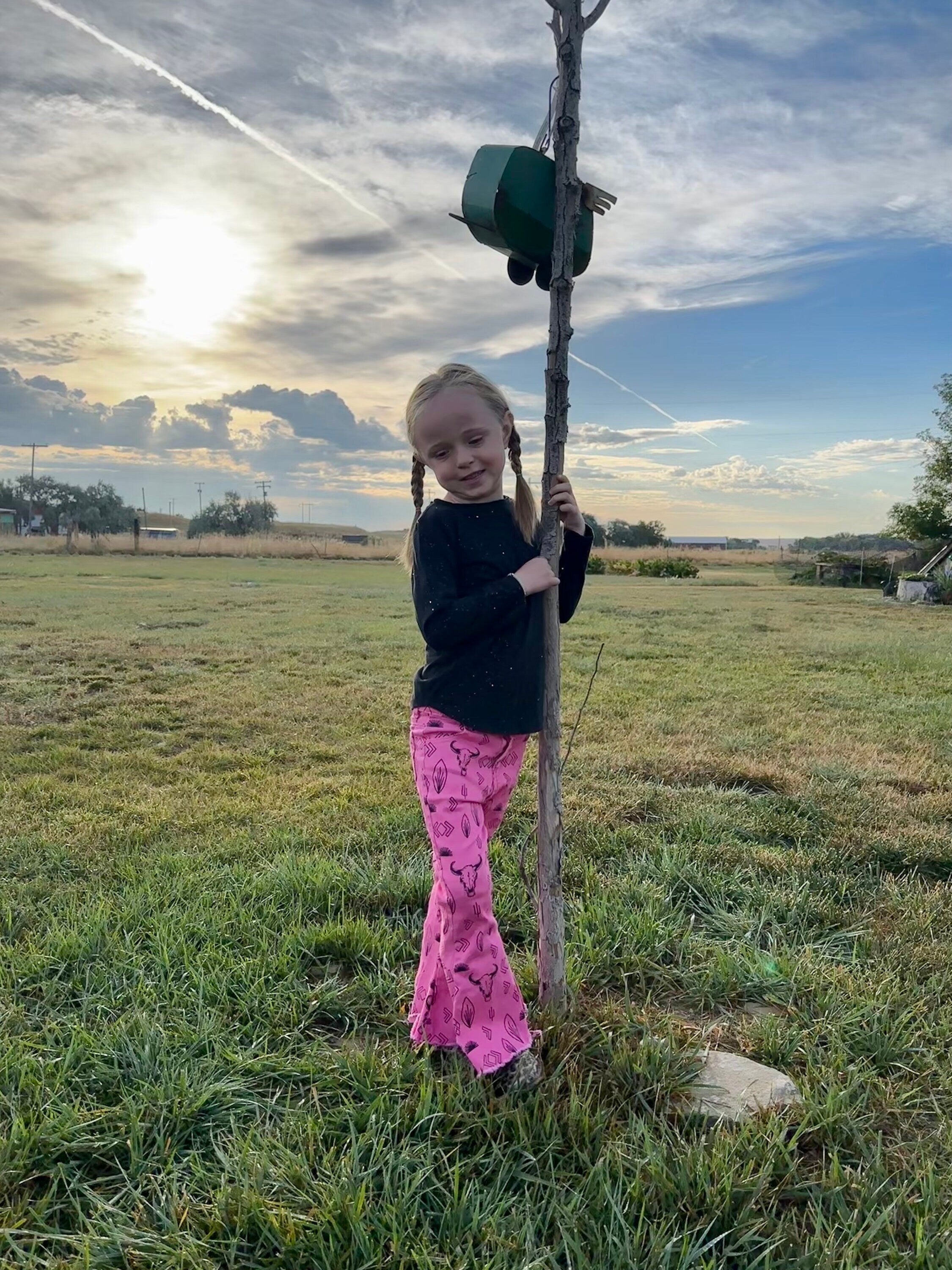 Jernie modeling girls hot pink western jeans. Jeans feature black steerheads, arrows, and cacti in an awesome western motif. Jeans have an adjustable waistband, pockets, and a frayed bell bottom hem.