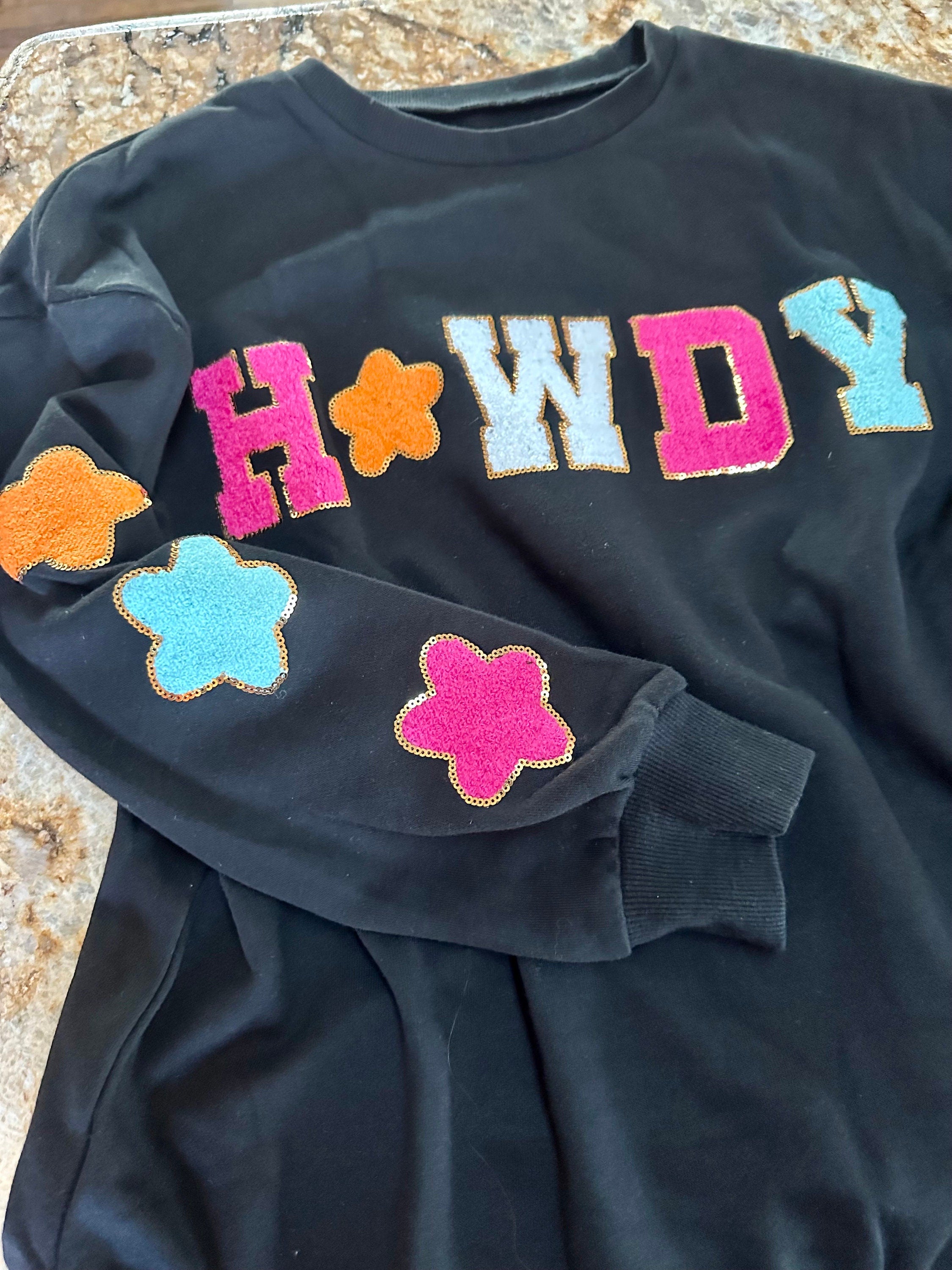 Howdy Sweatshirt – Glitter Patch Cowgirl Sweatshirt for Western Vibes! Add some sparkle to your casual wardrobe with our Howdy Sweatshirt. This women’s Western sweatshirt features a dazzling glitter patch “Howdy” design with matching stars!
