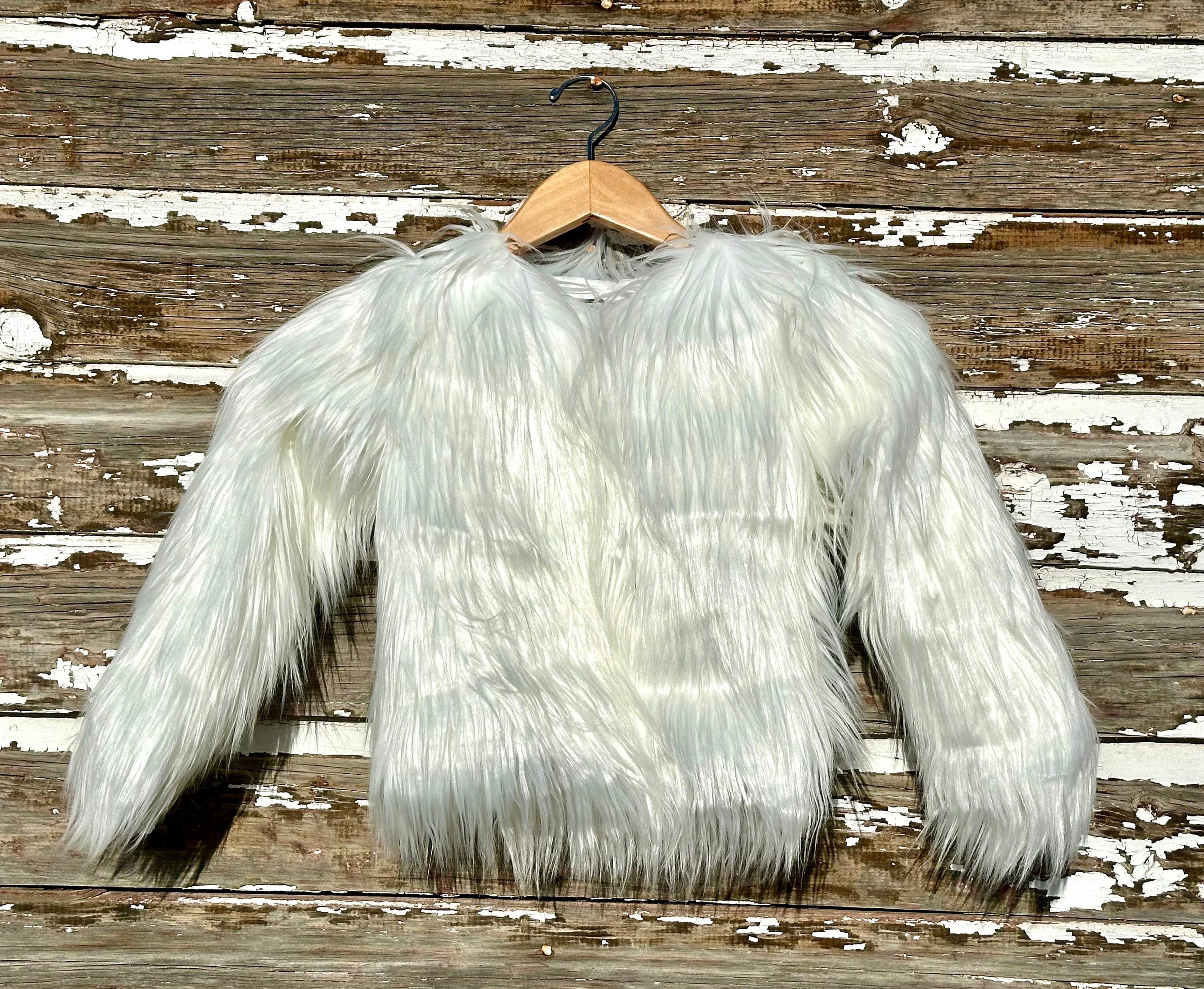 Girls white fur coat features a fabulous shaggy fur exterior, silky smooth lining, and convenient eye and hook closures. She’ll feel and look like a princess in this stunning coat from Razels.