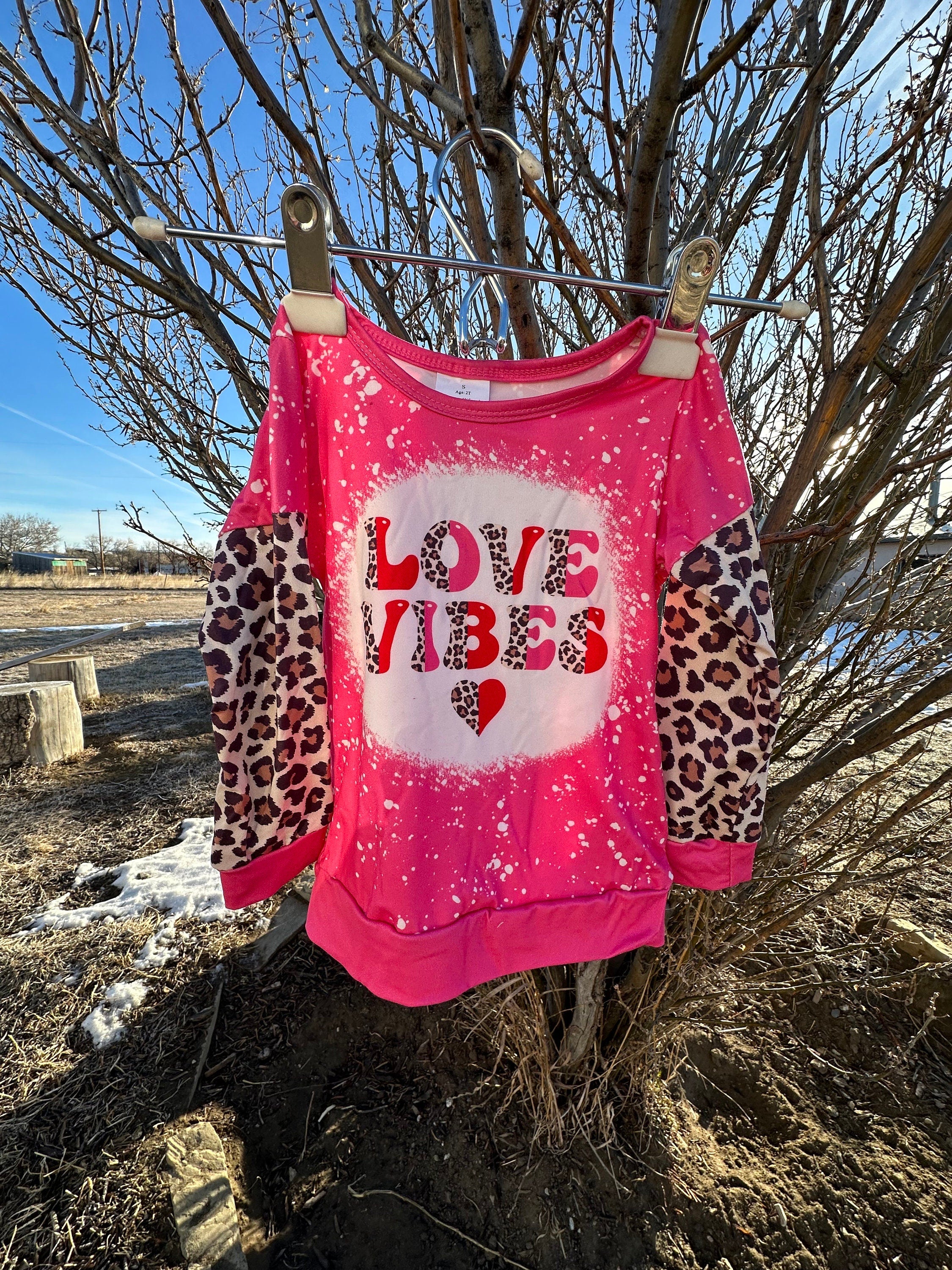 Girls Love Vibes Shirt with animal print sleeves.