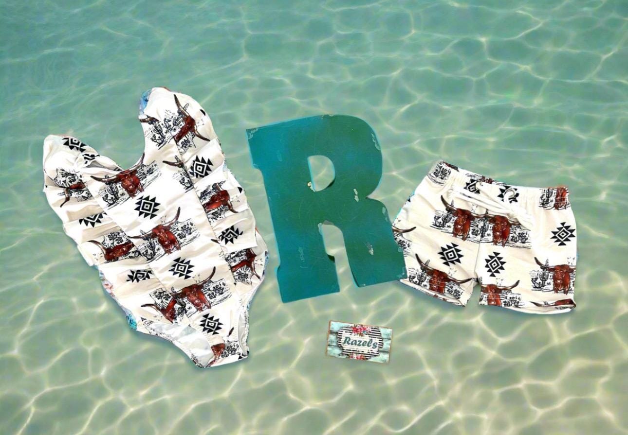 Western Swimsuits – Longhorn Steer Sibling Swimsuits. Get ready for summer with these Matching Swimsuits featuring a bold Longhorn Steer design! This black-and-white desert scene with a geometric touch is perfect for little cowboys and cowgirls who love Western style. 
 Cowboy Swim Trunks: Unlined for comfort, with a functional drawstring—also great as stylish day shorts!
Cowgirl Swimsuit: An adorable one-piece swimsuit with front ruffles fit for little rodeo queens!
