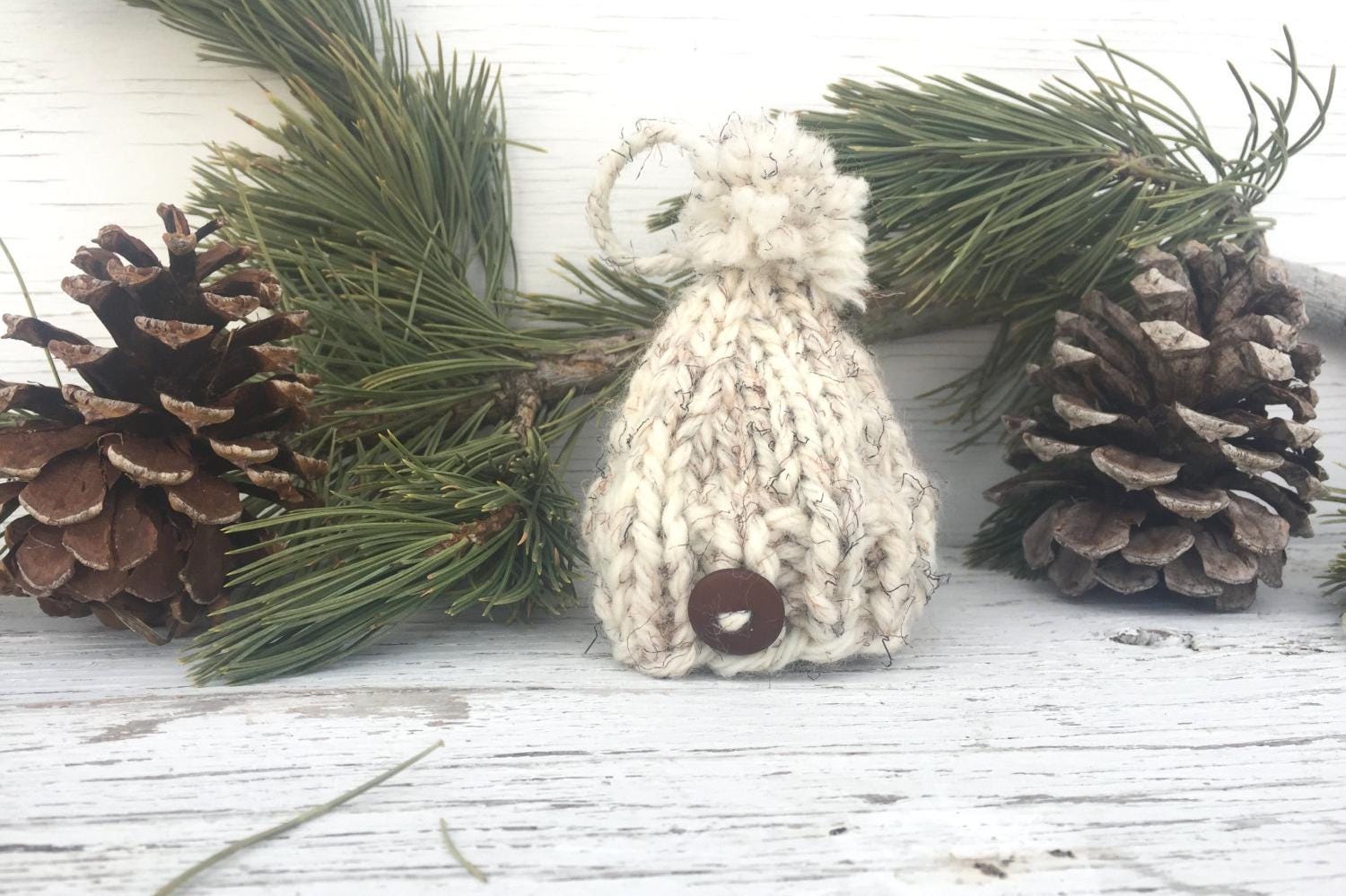 Handknit Mini Hat Christmas Tree Ornament. This hat is a white with black and brown flecks and a brown button centered on the brim. Hat also has an adorable, matching pom pom.
