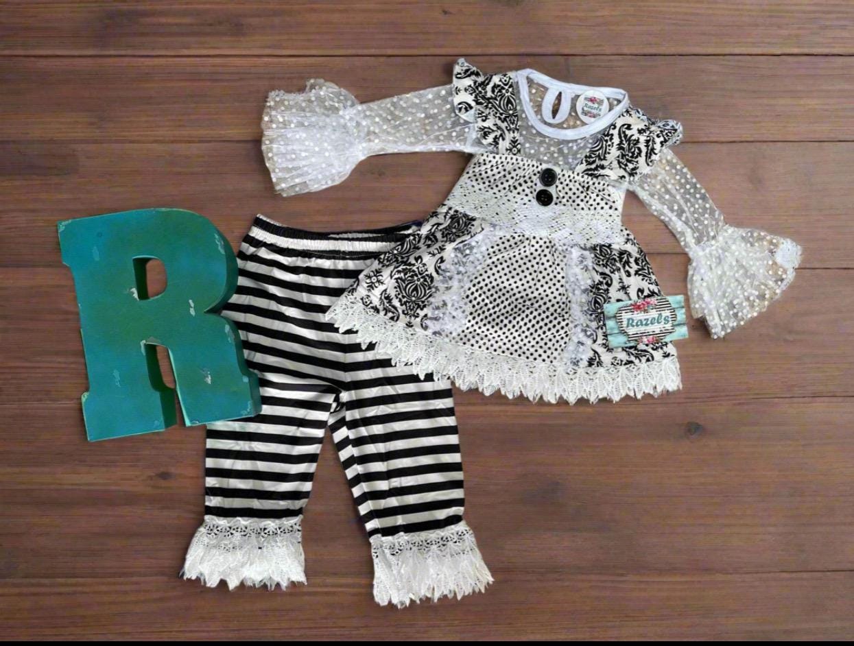 Black and White Lace Outfit – A Stunning 3-Piece Set for Little Girls. This Girls' Lace Top, Tunic Tank, and Striped Pants set is a timeless and elegant choice for special occasions. Whether for a family gathering, formal event, or a more somber occasion, this outfit is as versatile as it is stylish.
3 Piece set includes lace  ruffle shirt, tunic tank and striped pants with a lace hem. This set ships FREE from Montana with $35+ purchase from RAZELS.