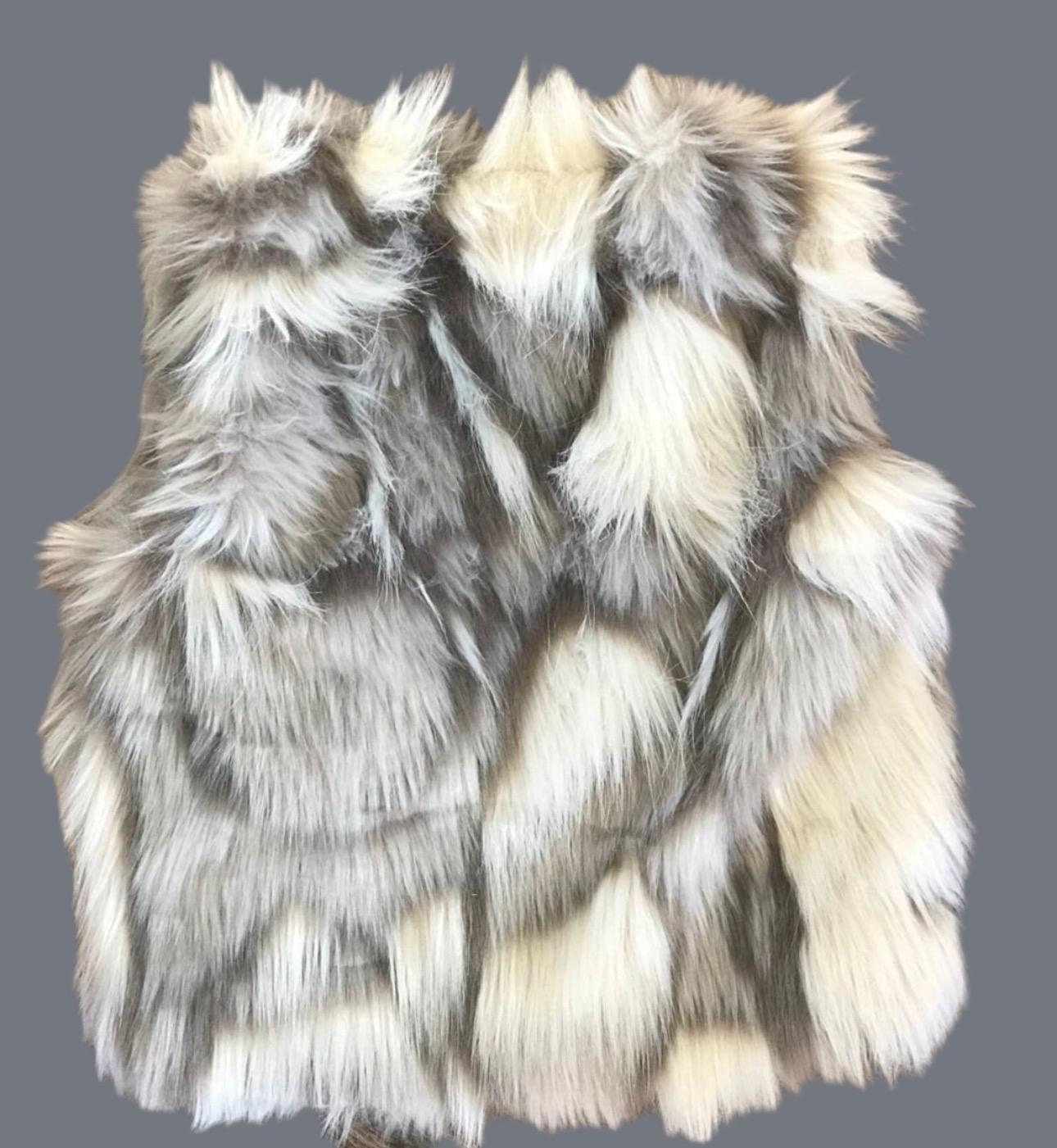Cozy and stylish Kids' Fur Vest in a blend of grey, black, brown, and cream. Perfect for layering over any outfit, this well-made vest keeps your child warm and photo-ready. The versatile colors make it easy to mix and match with her wardrobe.