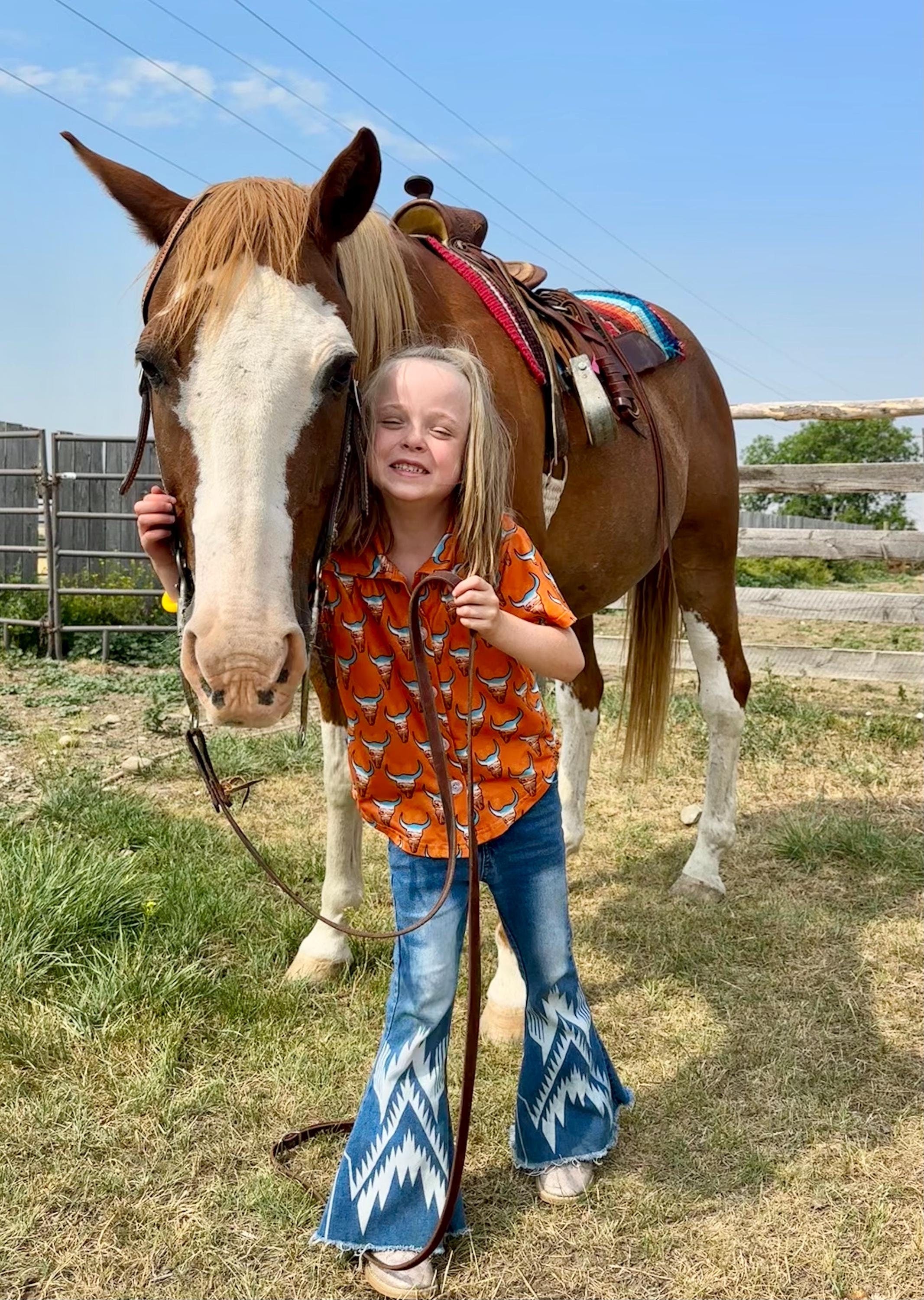 Give your little cowboy or cowgirl a shirt that’s as bold as the Wild West! 🤠🧡 This kids’ Western button-up shirt features steer heads filled with a desert highway sunset scene, all set on a bright orange background. It’s a standout piece for rodeos, family photos, or just everyday cowboy style.
✓ Classic button-up design with short sleeves
✓ Bright orange with steer head + desert scene print
✓ Perfect for Western outfits, rodeo kids, or cowgirl chic