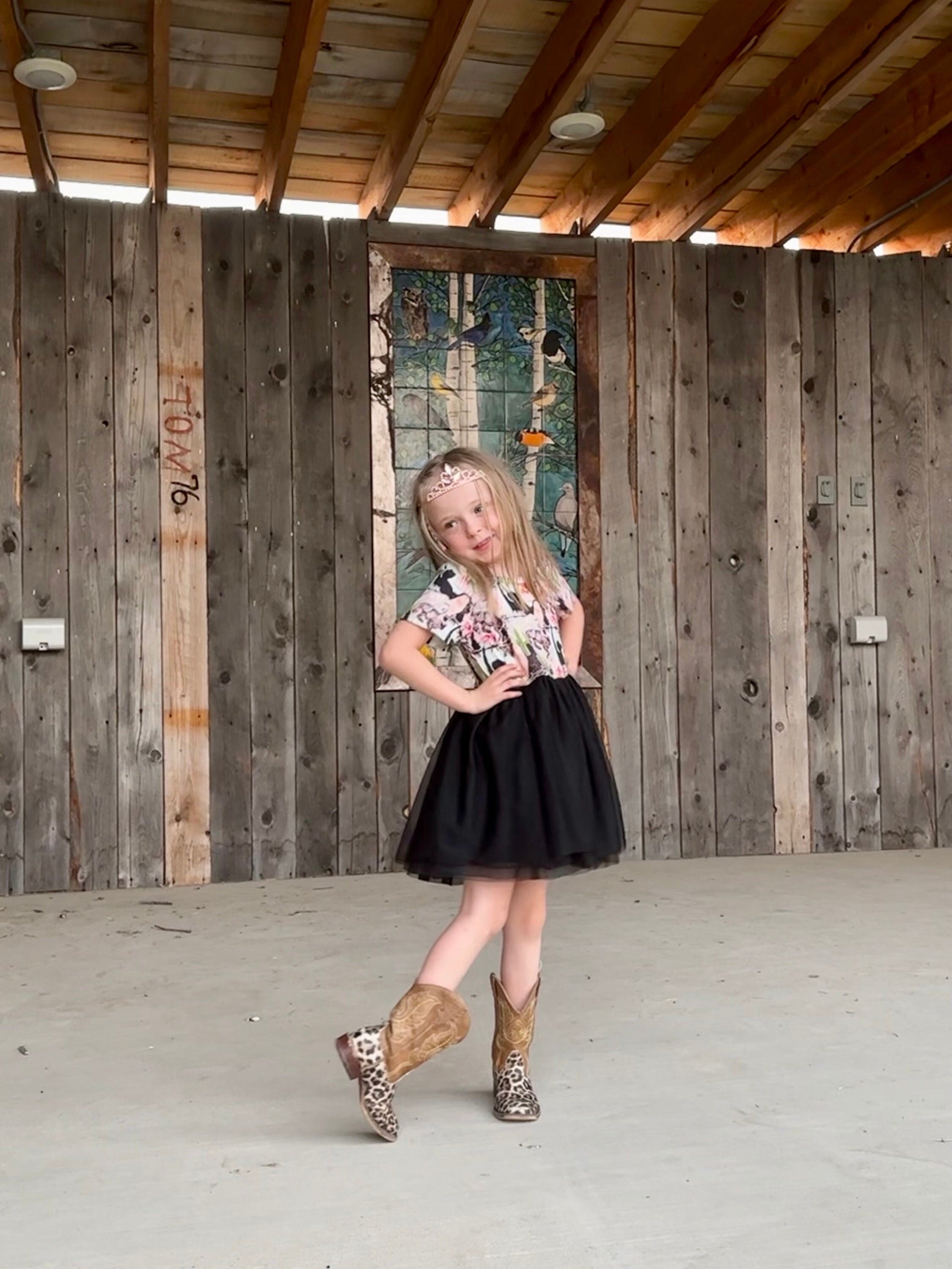 Western TUTU Cowgirl Party Dress modeled by Jernie. The dress features a super soft t-shirt-like top with a western print and the attached skirt is 3 layers of black tulle. Talk about a girl's western party dress!