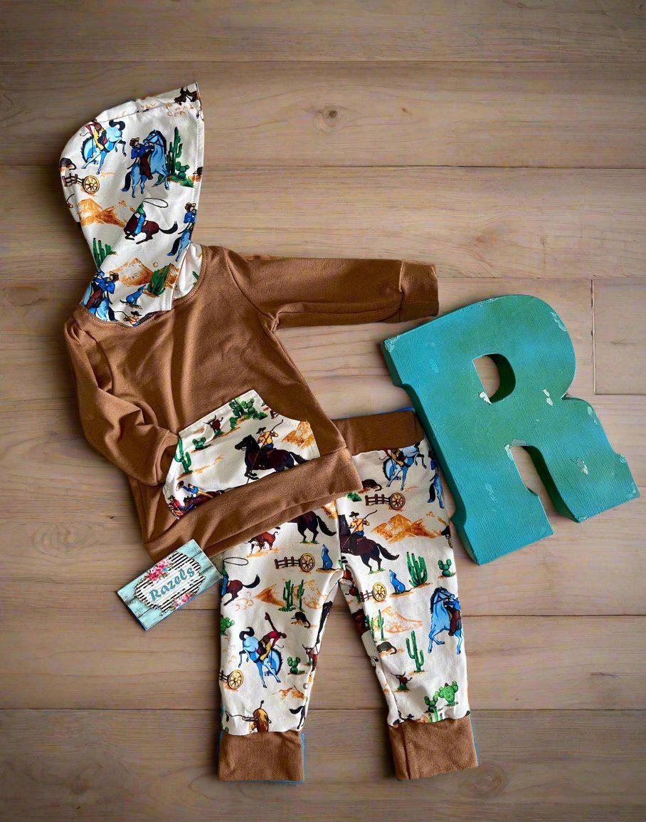 Little Cowboy Outfit – Exclusive to Razels!
Get your little cowboys ready for adventure with this Boys Western Outfit, the perfect blend of style and comfort! This playful set features a lightweight hoodie sweatshirt with a convenient kangaroo pocket and coordinating cowboy-print jogger pants. The retro cowboy design adds a fun and nostalgic vibe, making this outfit perfect for any little cowboy who loves to ride in style! 🤠 SHIPS FREE WITH $35 ORDER FROM MONTANA