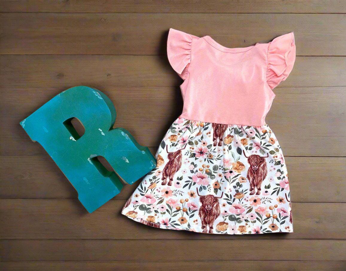 Scottish Highland Cow Dress! 🐄💖 It's the perfect blend of comfort and style, featuring a cute floral highlander cow print on the bottom. The soft top has flutter sleeves, a collar, and button details for an added touch of charm. Ships FREE with $35