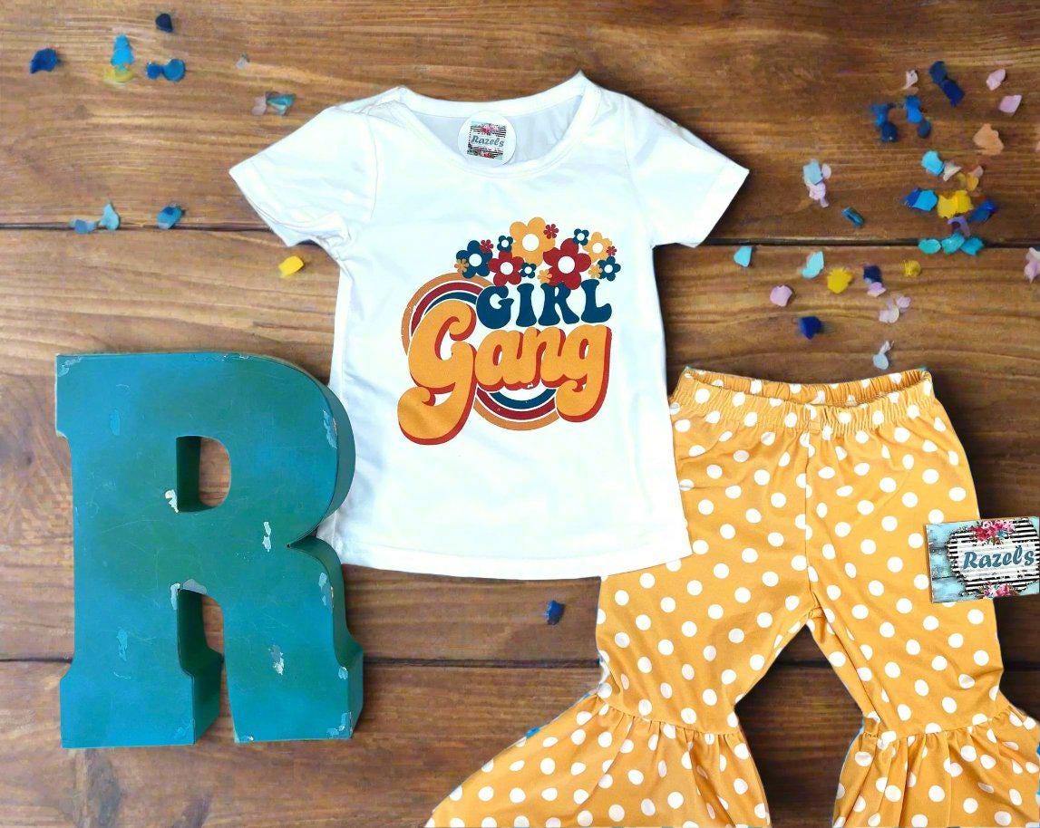 Girl Gang Shirt and Yellow Polka Dot Bell Bottom Outfit – Retro Floral Vibes for Girls! 🌼💪🏽
This fun, bright Polka Dot Bell Bottom outfit is perfect for your little fashionista! I love the retro floral vibe, and what could be more fun than yellow polka dot bell bottoms? This adorable outfit is ready for sunshine and warm weather! 🌞 Or, pair it with a denim jacket for those cooler days, especially if you live in Montana like us! 😉🤠Ships FREE with $35+ purchase from MONTANA.