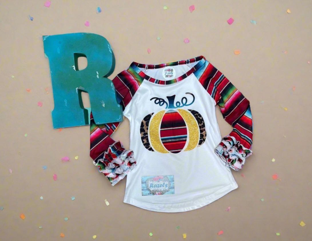 Fall Stripes Pumpkin Ruffle Sleeve Shirt. This Fall Shirt features a pumpkin with Fall serape stripes, cheetah print and glitter gold. The neckline and sleeves are festive serape stripes with wrist ruffles. So cute!