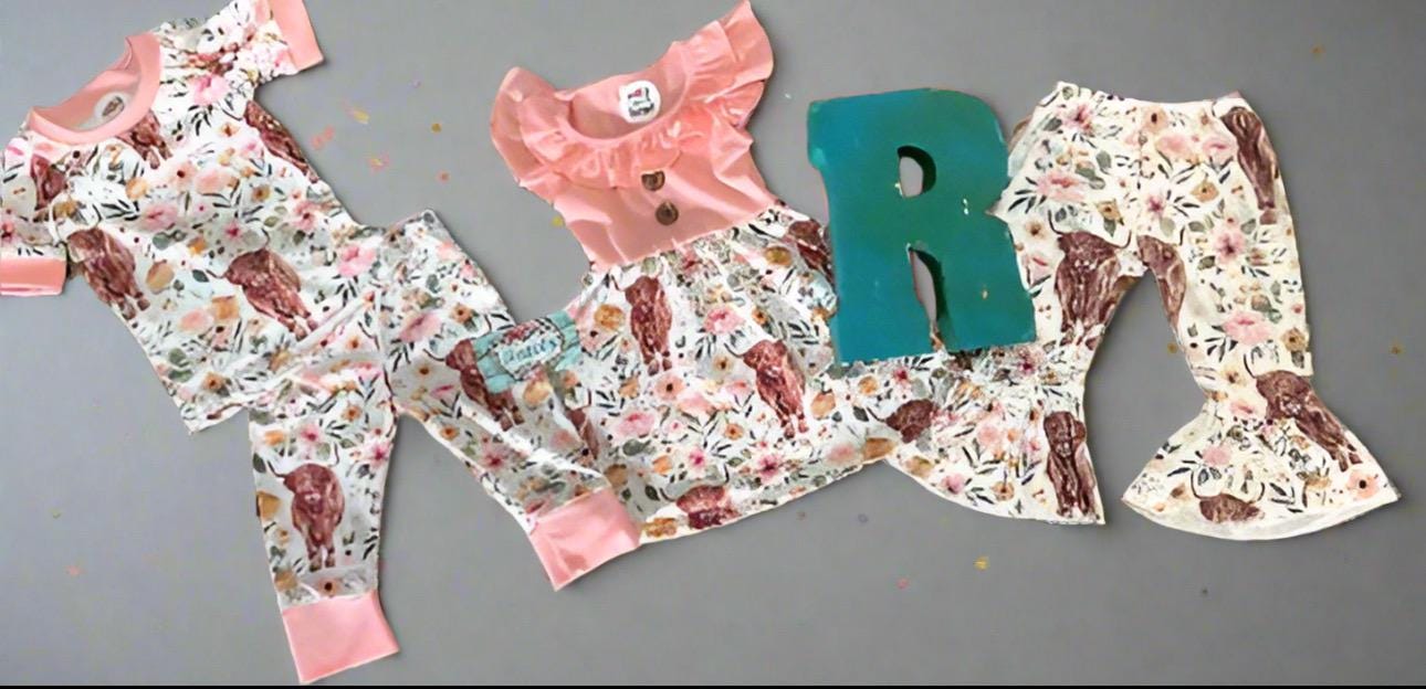 Razels collection of Highlander Cow girls clothing. The sweet floral highlander cow fabric is available in girls pajama set, dress and bell bottom pants.