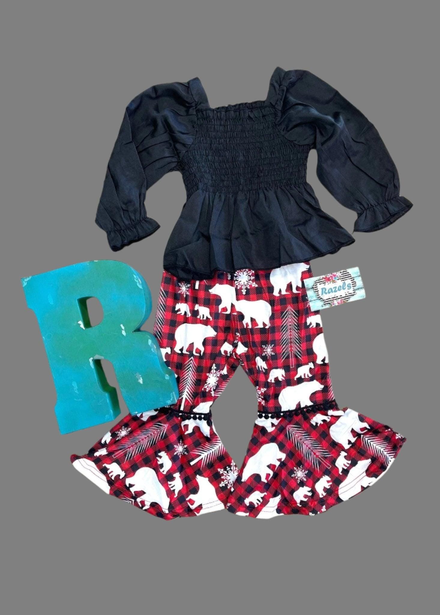 Toddler Girl Christmas outfit featuring a stunning black blouse paired with holiday-themed pants featuring red buffalo plaid bell bottoms adorned with white bears and trees.