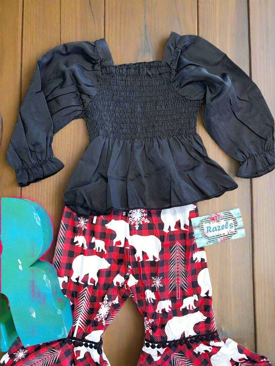 Toddler Girl Christmas outfit featuring a stunning black blouse paired with holiday-themed pants featuring red buffalo plaid bell bottoms adorned with white bears and trees.
