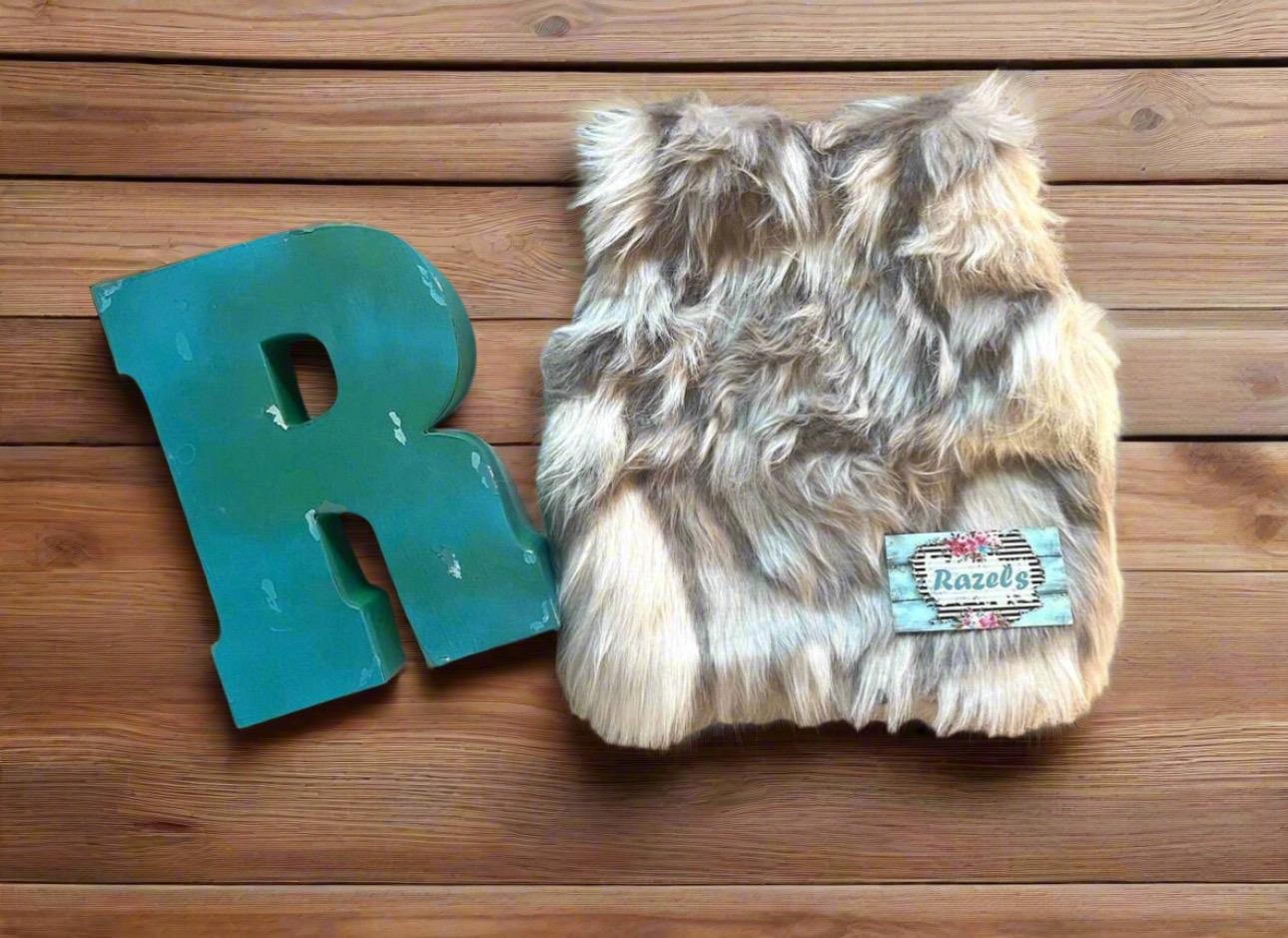 Cozy and stylish Kids' Fur Vest in a blend of grey, black, brown, and cream. Perfect for layering over any outfit, this well-made vest keeps your child warm and photo-ready. The versatile colors make it easy to mix and match with her wardrobe.