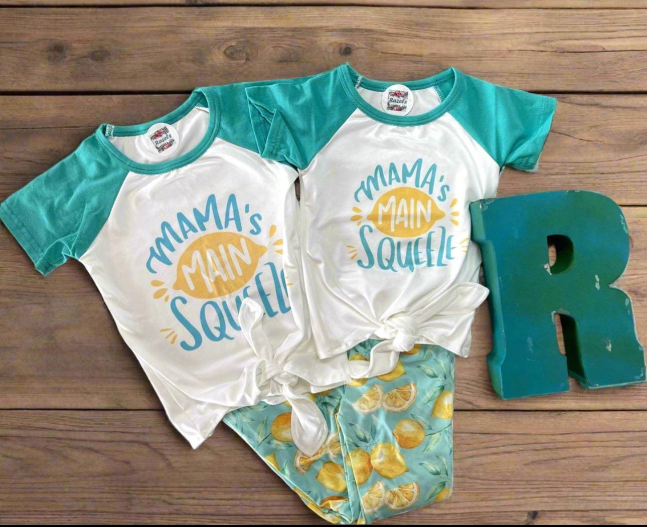 🍋 Mama's Main Squeeze Bell Bottom Outfit - a cheerful lemon-themed outfit! This adorable set features a playful "Mama's Main Squeeze" t-shirt and bell bottoms with an all over lemon print, adding a burst of sunshine to any day.