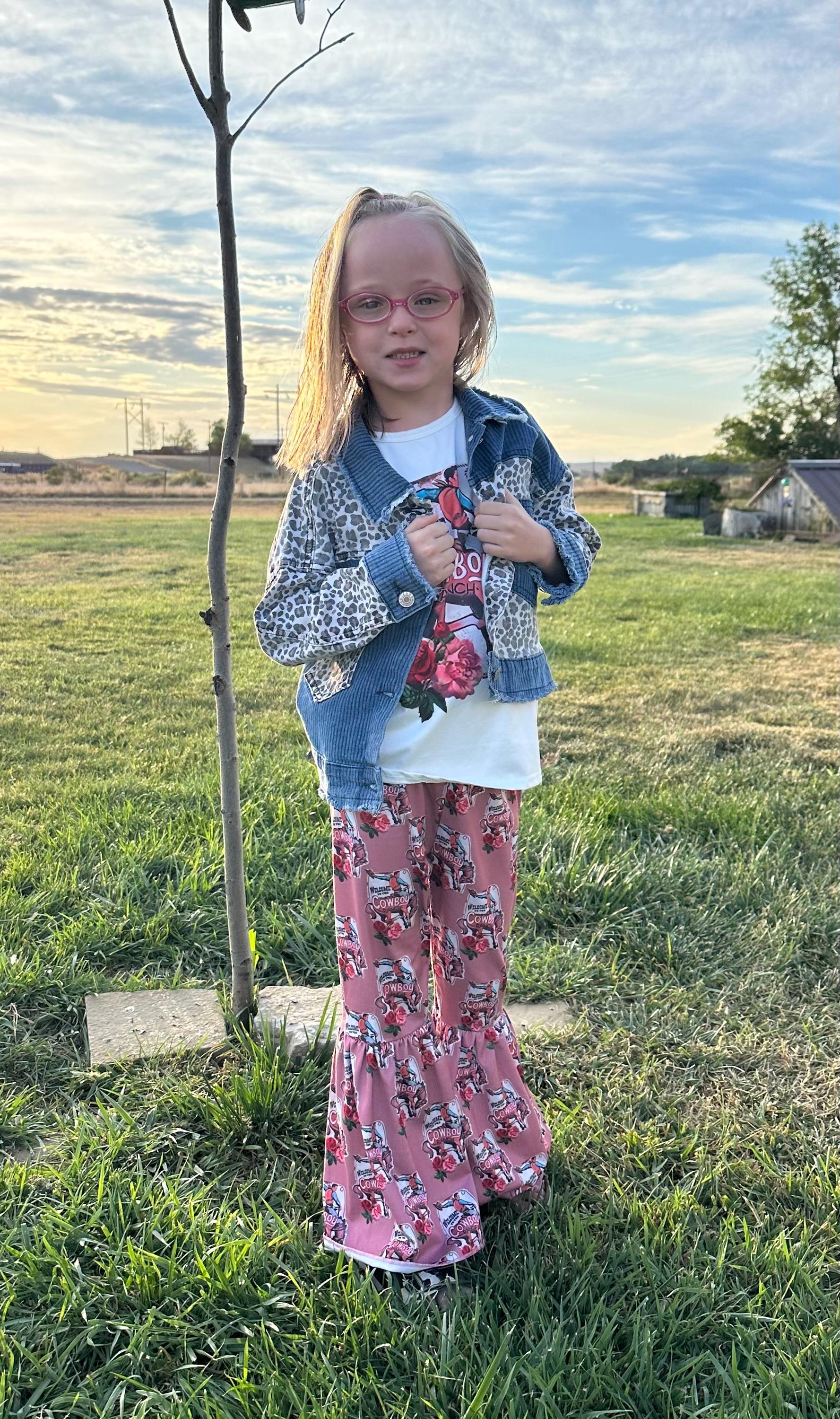 Jernie modeling the Cowboy Ranch Bell Bottom outfit, cowprint sandals and cheetah and denim jacket.