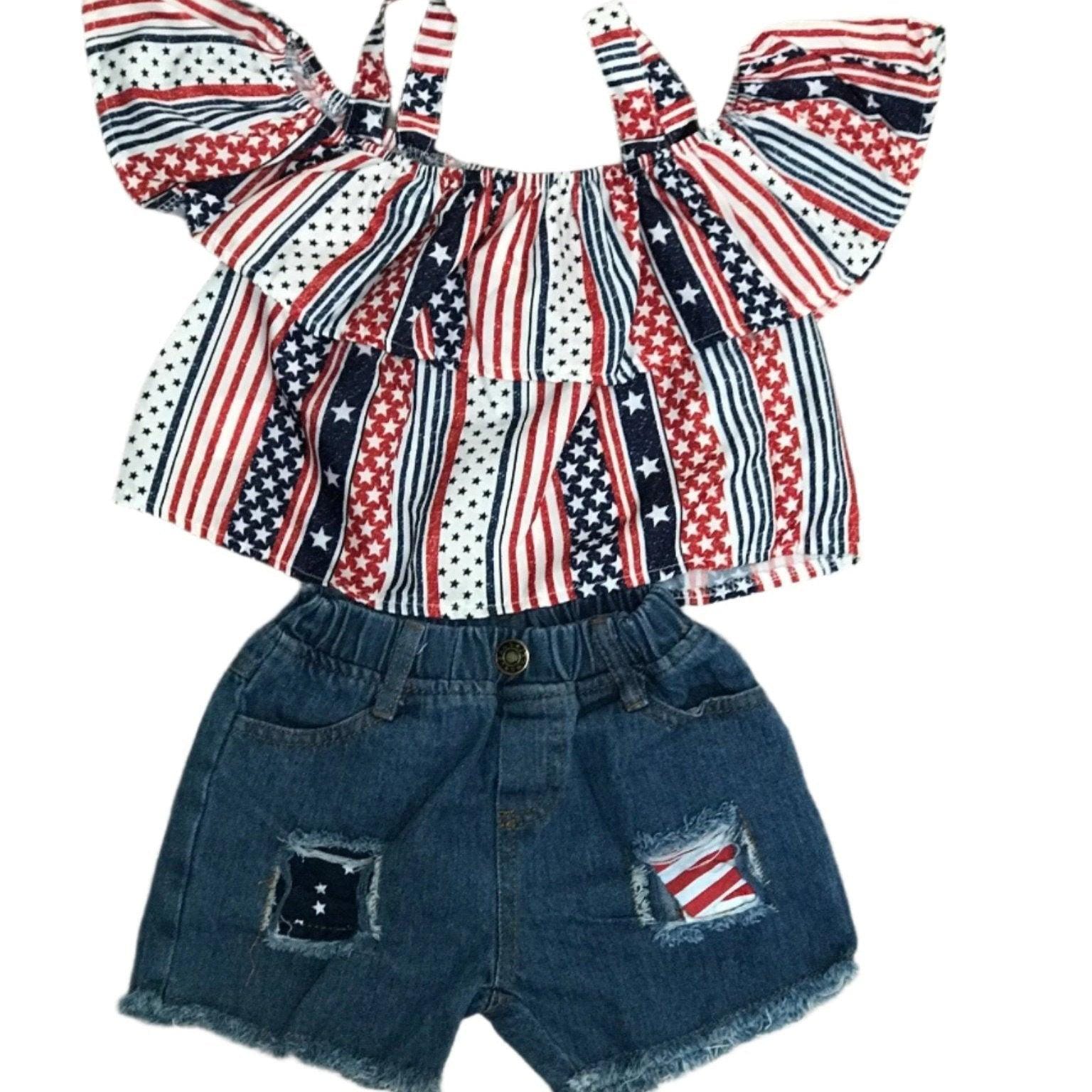 4th of July Toddler Outfit | Flag Shirt & Distressed Jean Shorts Set | USA Kids Clothes | Sizes 2T–5T ⭐ 50% OFF! ⭐ Oh my stars… and stripes!
This 4th of July short outfit is the ultimate summer must-have for your little firecracker! Classic light-wash denim with festive red, white, and blue peeking through the distressed details.
A bold American flag print meets sweet style with cold-shoulder cutouts and a flouncy ruffle.