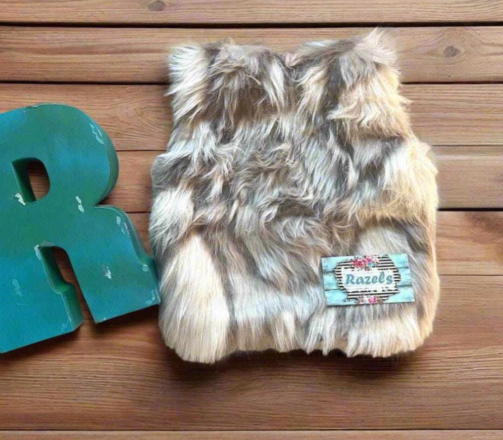 Cozy and stylish Kids Fur Vest in a blend of grey, black, brown, and cream. Perfect for layering over any outfit, this well-made vest keeps your child warm and photo-ready. The versatile colors make it easy to mix and match with her wardrobe.