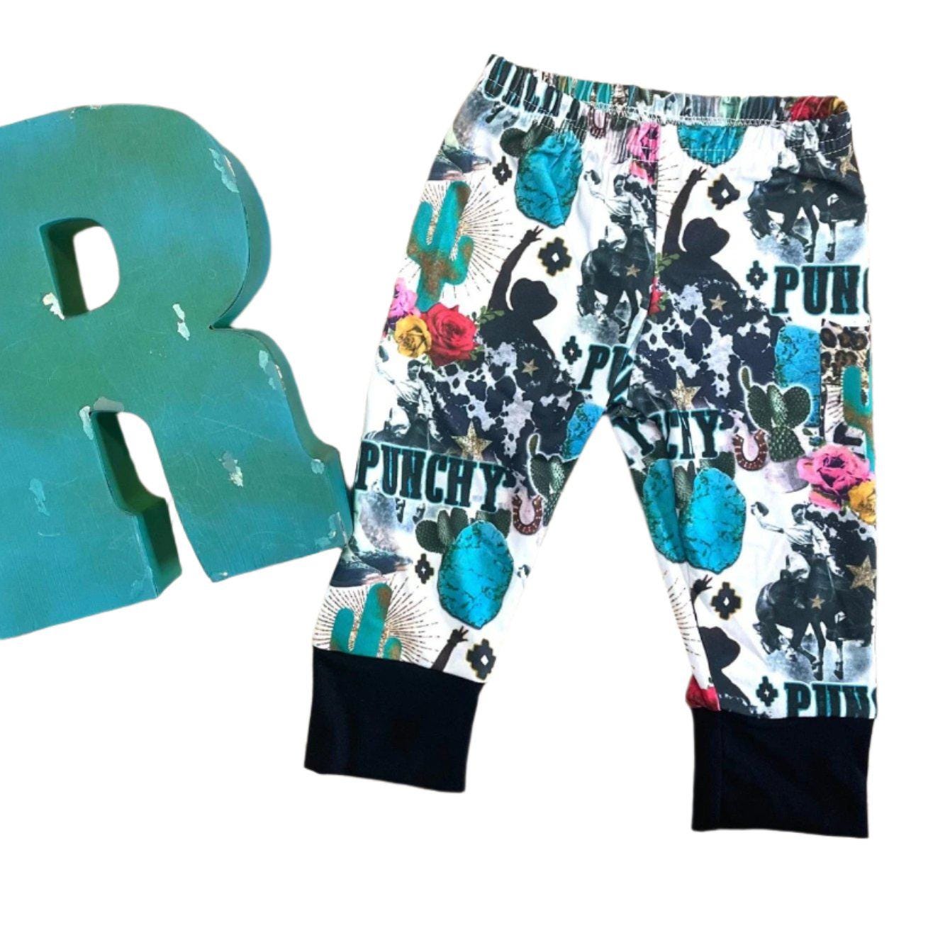 Girls Cowgirl Outfit | Western Hoodie Jogger Set for Kids This Girls PUNCHY Cowgirl Outfit is full of retro cowboy vibes. This Western outfit features an allover Western print with matching jogger pants and a lightweight, short-sleeved hoodie top.