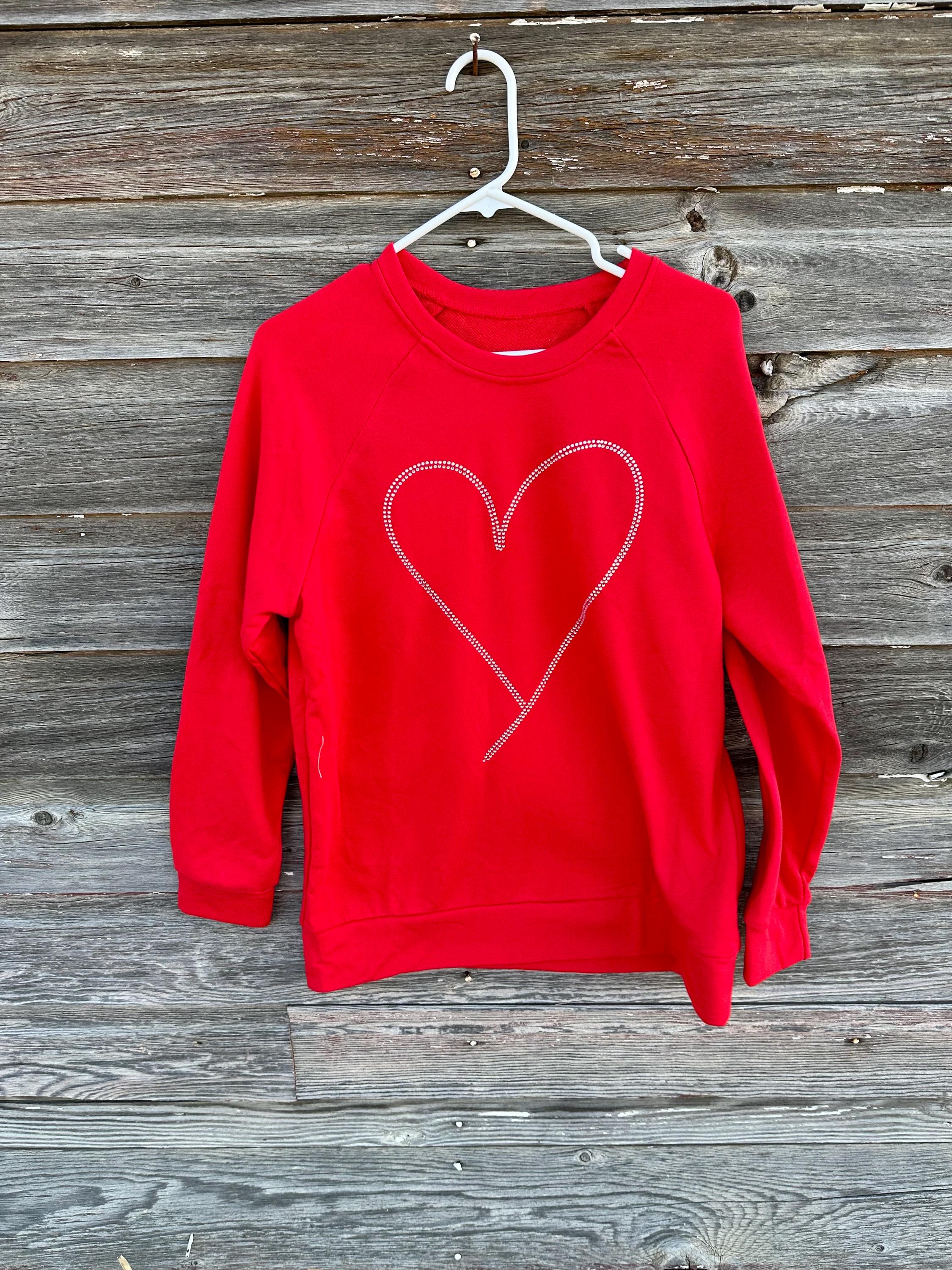 Add sparkle to your style with the Rhinestone Heart Shaped Sweatshirt! Featuring a glittering heart design, relaxed neckline, and cozy long sleeves, it's perfect for all-day comfort. Ships for FREE—shop Razels now!